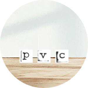 Three paper blocks with the letters P, V, and C on a wooden surface.