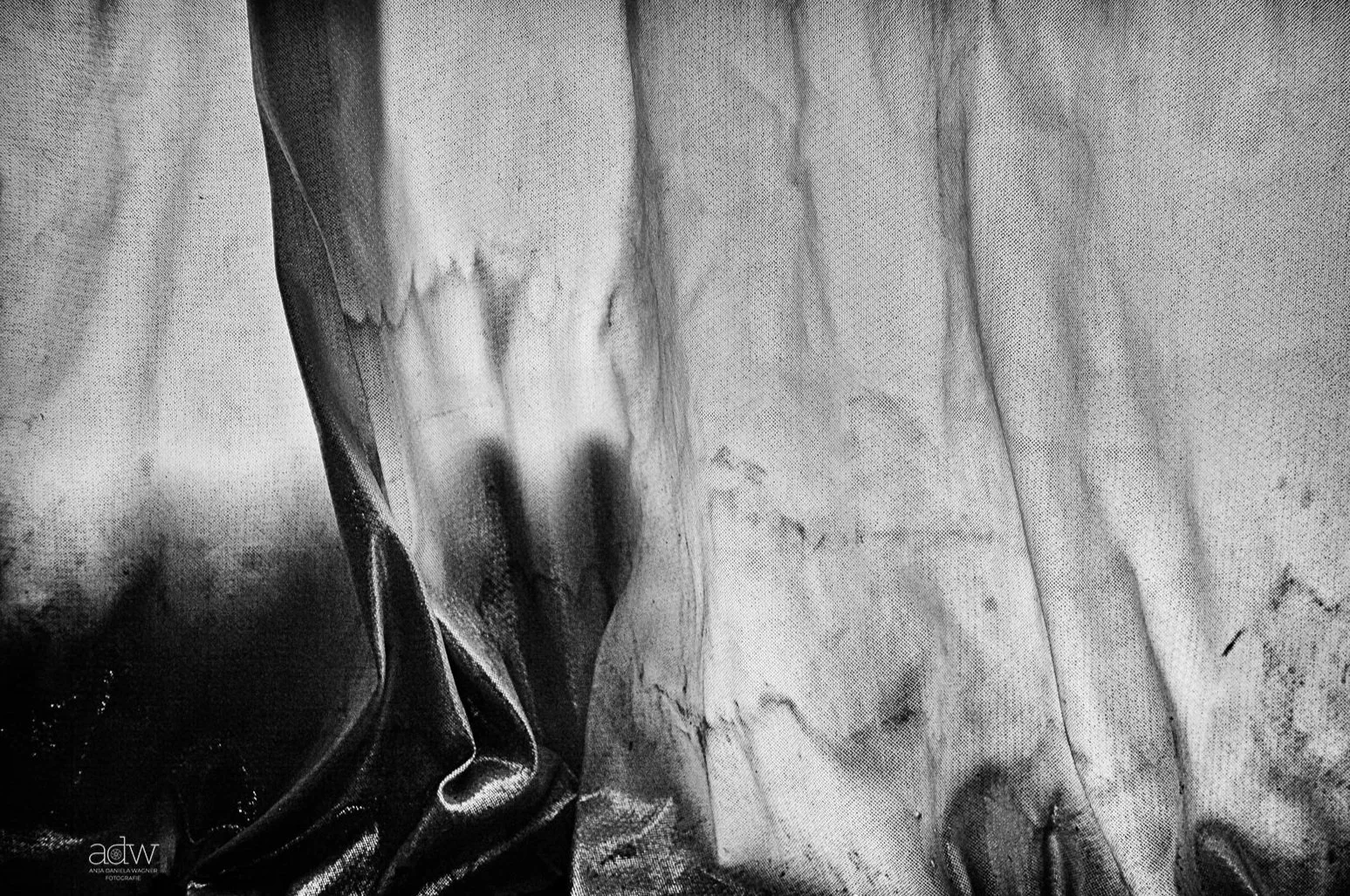Close-up of a black and white textured fabric surface with some wrinkles and folds.