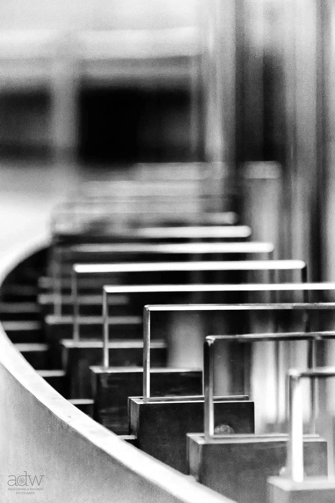 Close-up of stair rails and steps in black and white, with a blurred background.
