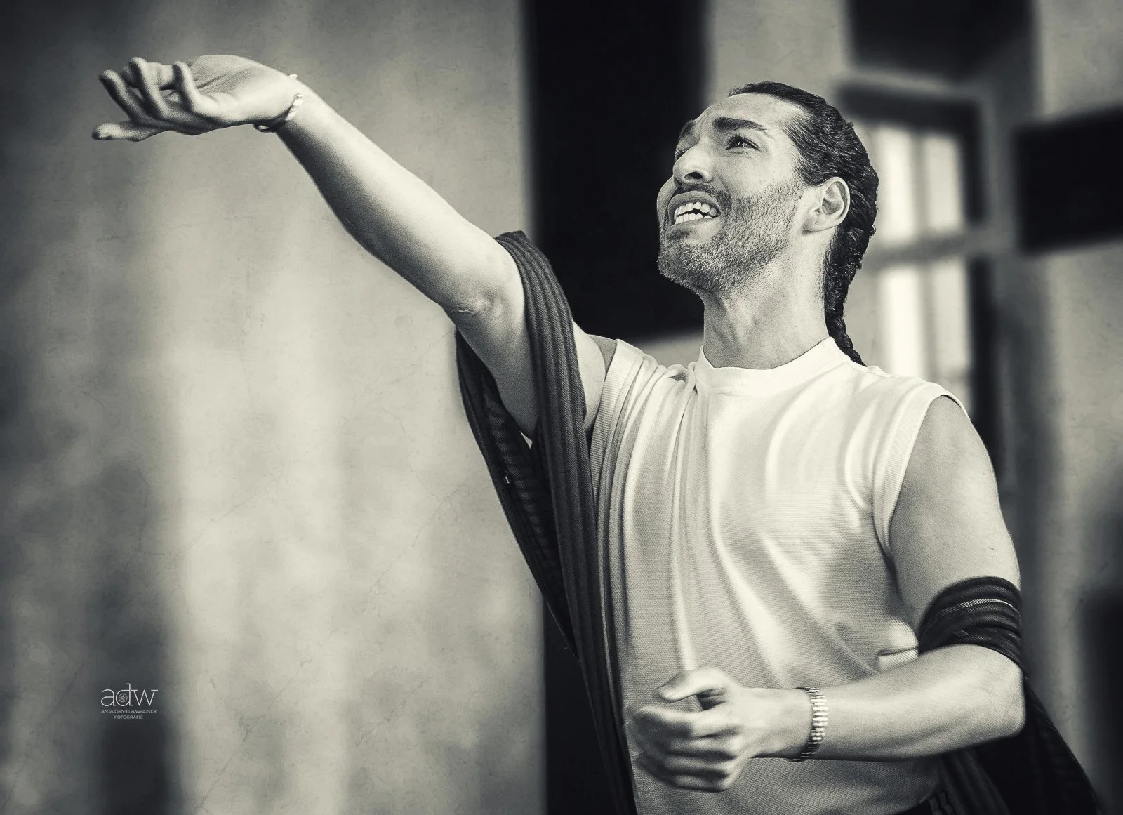 A man with a beard and mustache, smiling, is wiping his face with a towel.