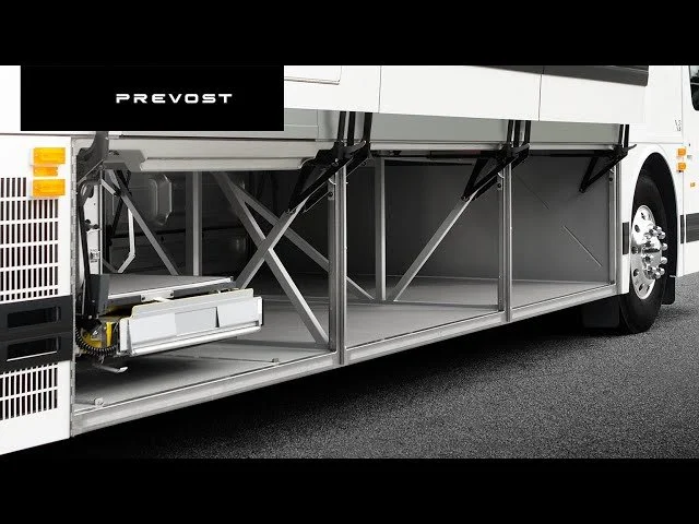 Open underside of a Prevost bus showing empty storage compartments.