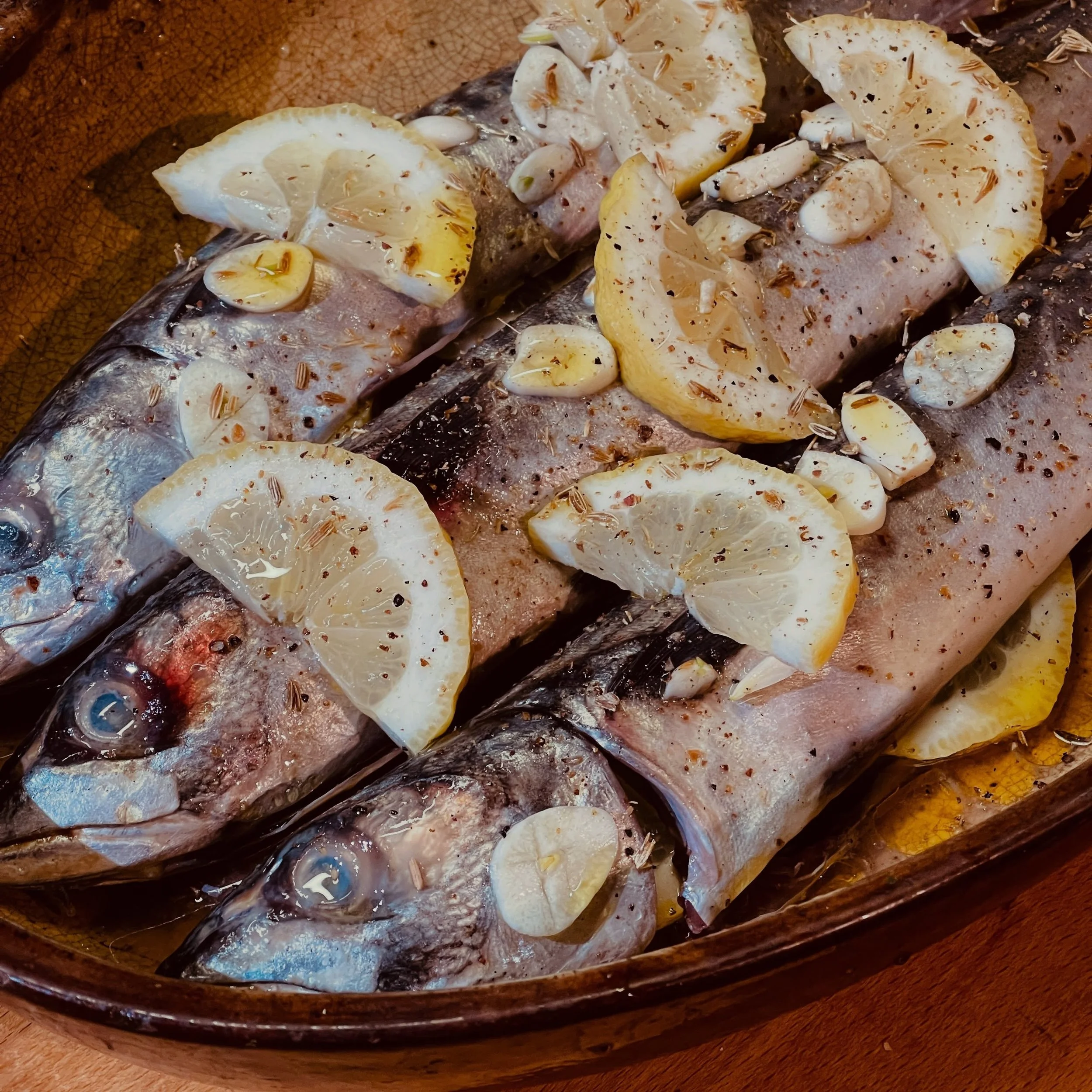 Bereit f&uuml;r den Ofen.
Ganze Fische, Zitrone, Knoblauch, Fenchel. Keine Filets, keine Tricks &ndash; nur das, was der Markt hatte.
So kocht man hier. Mit dem, was da ist. Mit den Augen noch drauf.
VOIL&Agrave; &ndash; Eine K&uuml;che in S&uuml;dfr