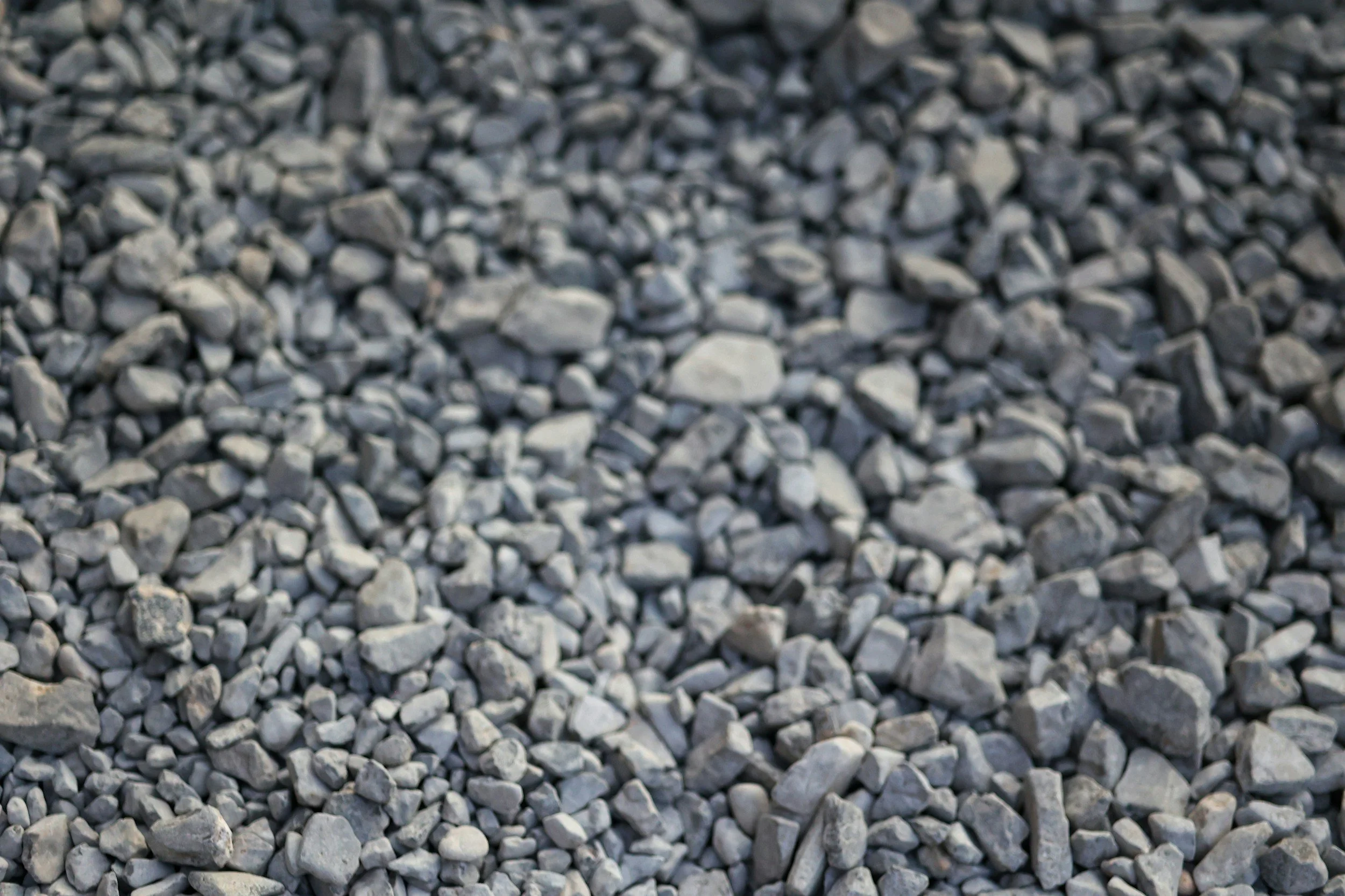 A close-up view of a large pile of small gray and white gravel stones.