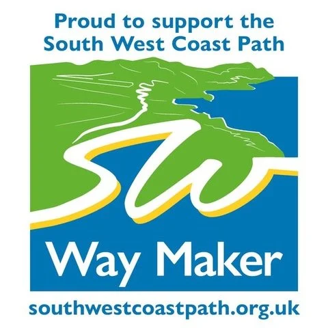 Logo supporting the South West Coast Path, featuring a green landscape with a winding white trail, blue water, and text promoting Way Maker at southwestcoastpath.org.uk.