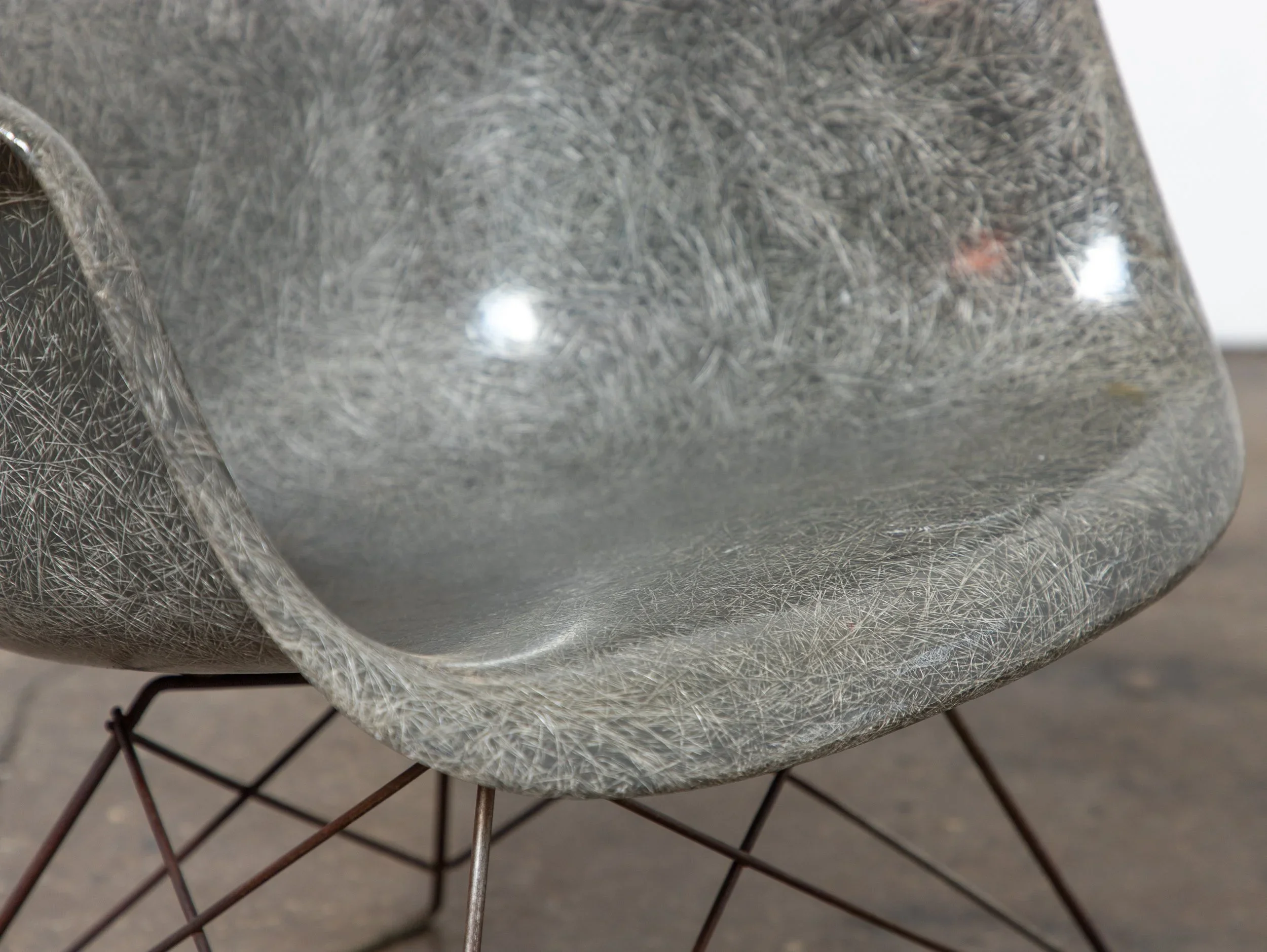 Close-up of a metallic, round object with a textured surface, resting on a wire mesh stand.
