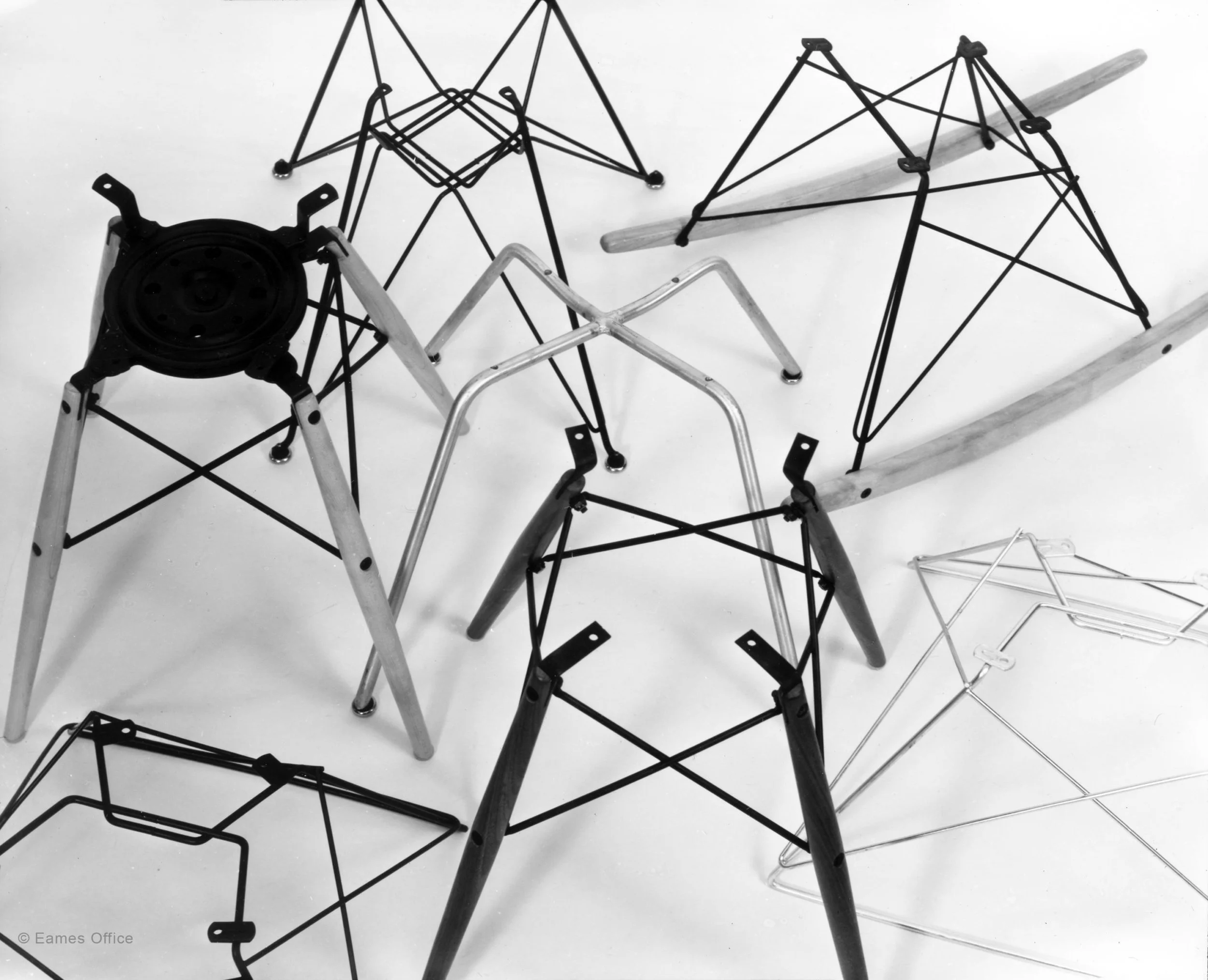 A collection of various metal and wooden structures and a plastic post, placed on a white surface.