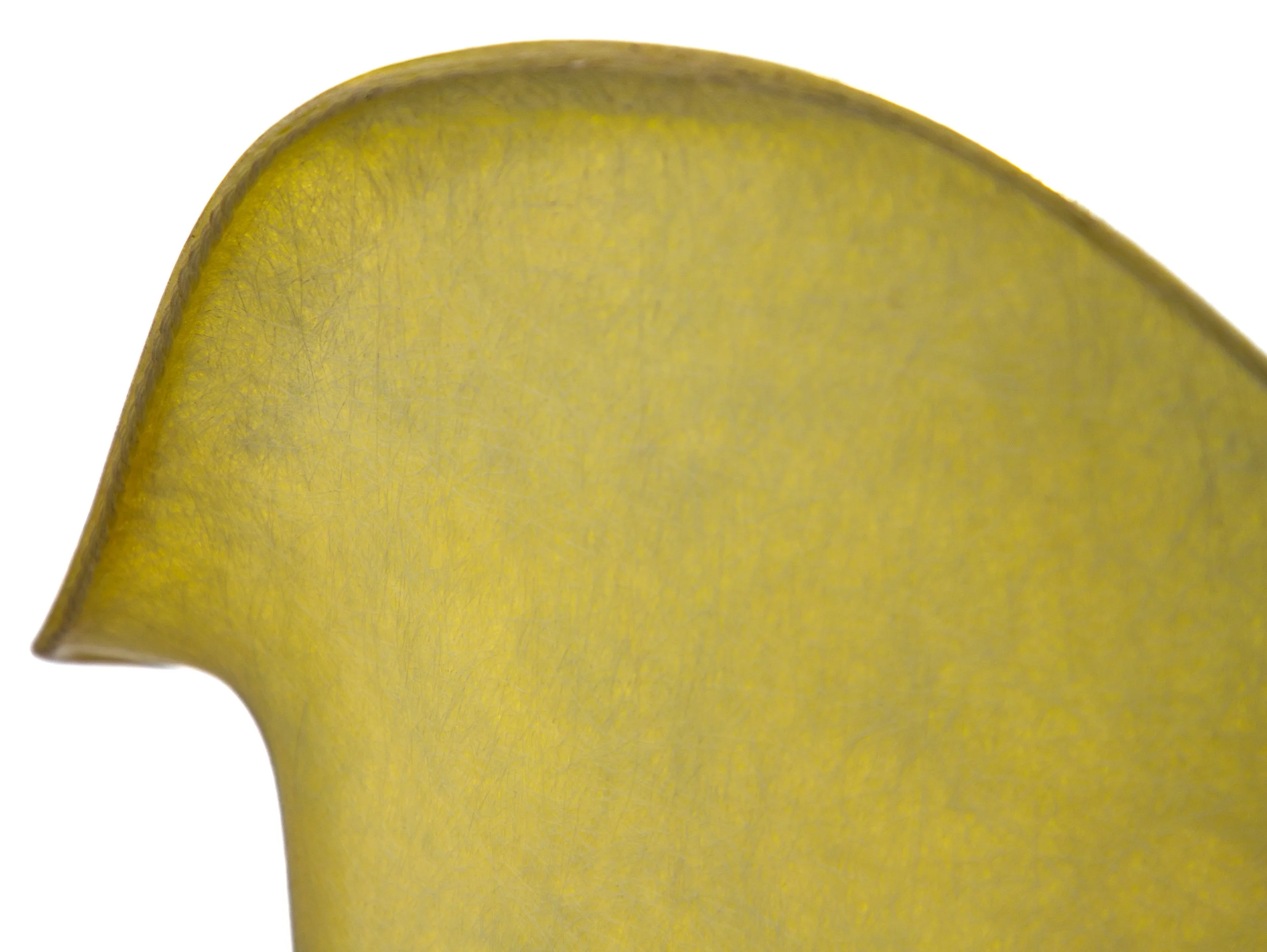 Close-up of a yellow paper or fabric with curved edge and visible texture.