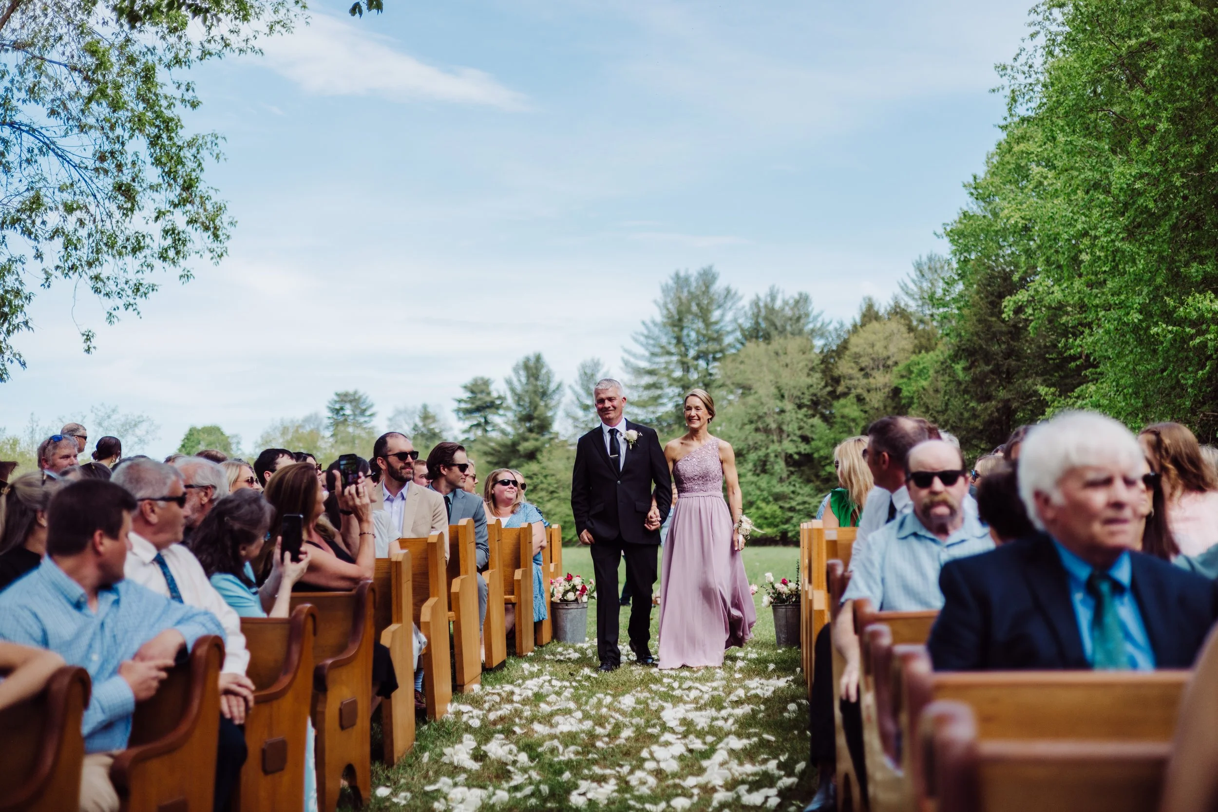 Guests seated for an outdoor ceremony with sweeping countryside views at Swiss & Bloom Farm.