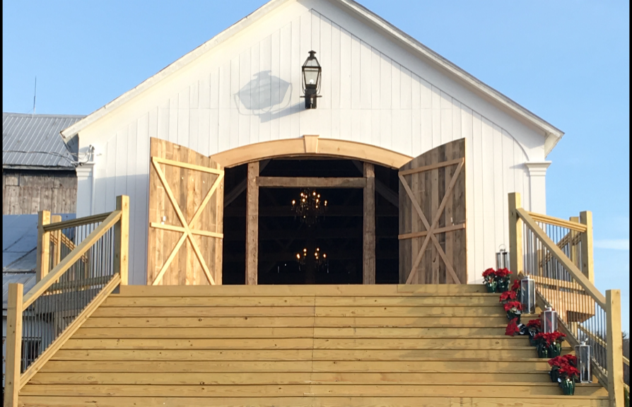 The Wedding Barn at Swiss & Bloom Farm with open doors and chapel‑style steps decorated for a ceremony.