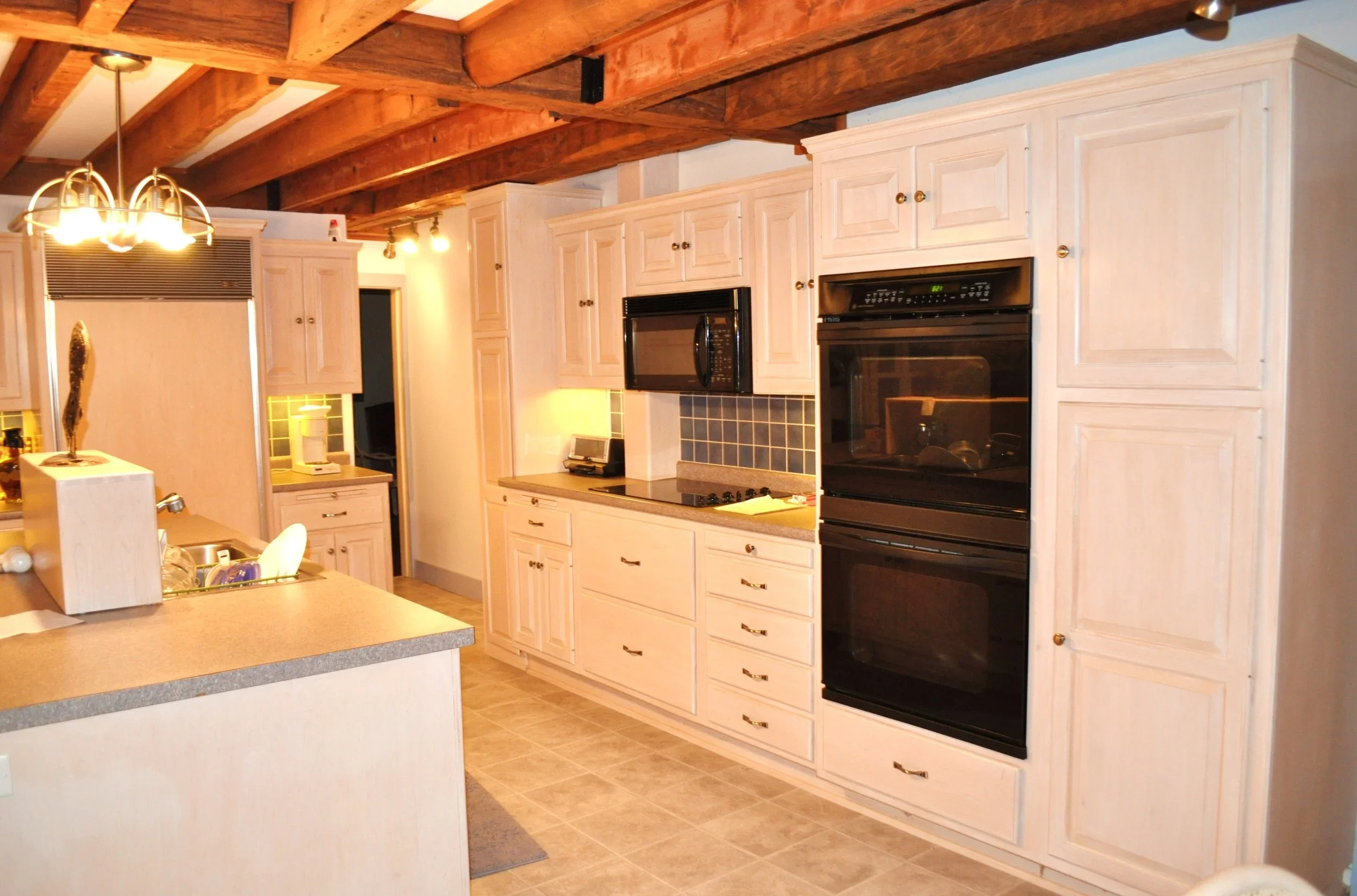 Bright farmhouse kitchen with exposed beams and double ovens, perfect for wedding‑weekend gatherings at Swiss & Bloom Farm.