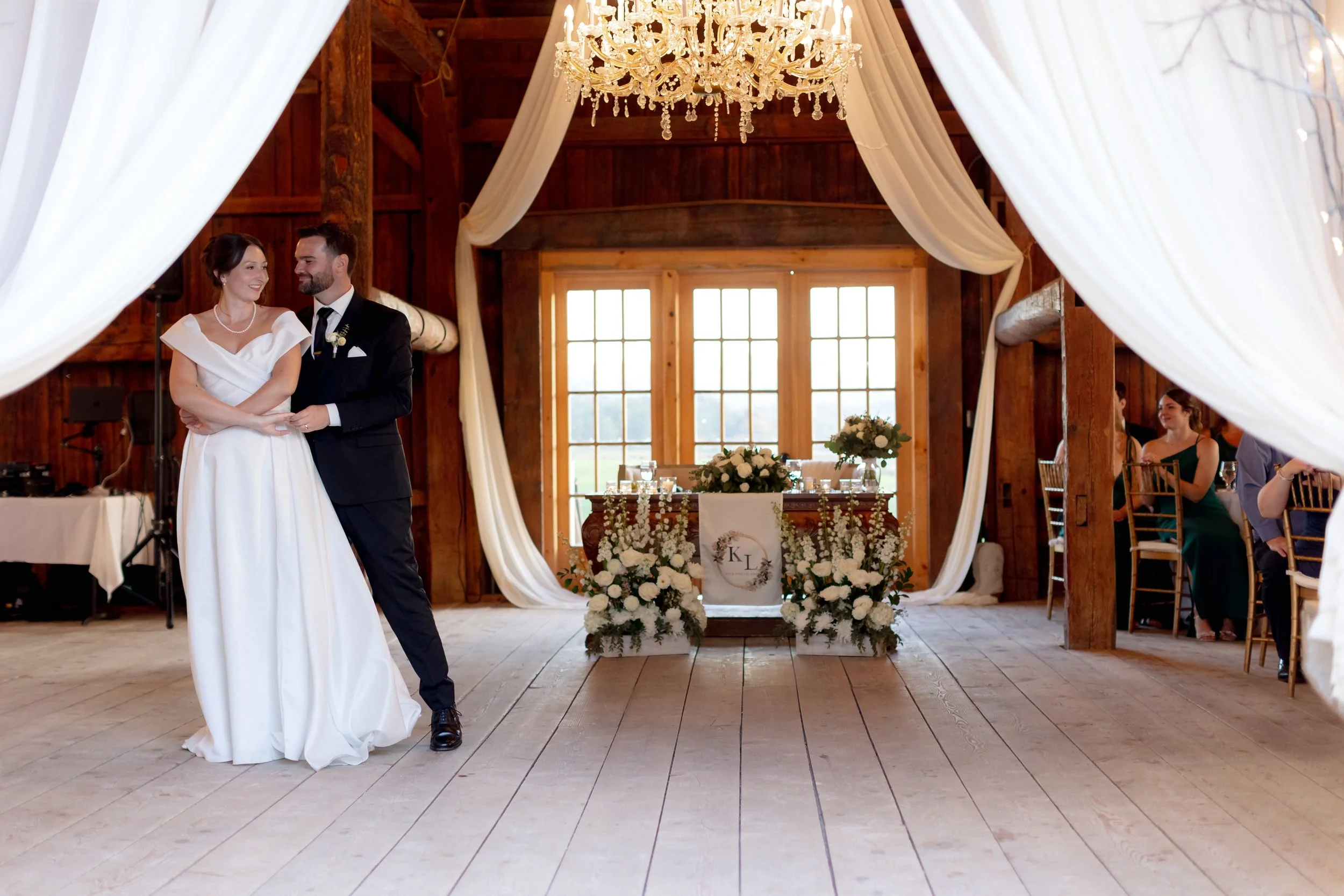 Newlyweds dancing during a joyful reception inside the restored Wedding Barn at Swiss & Bloom Farm.