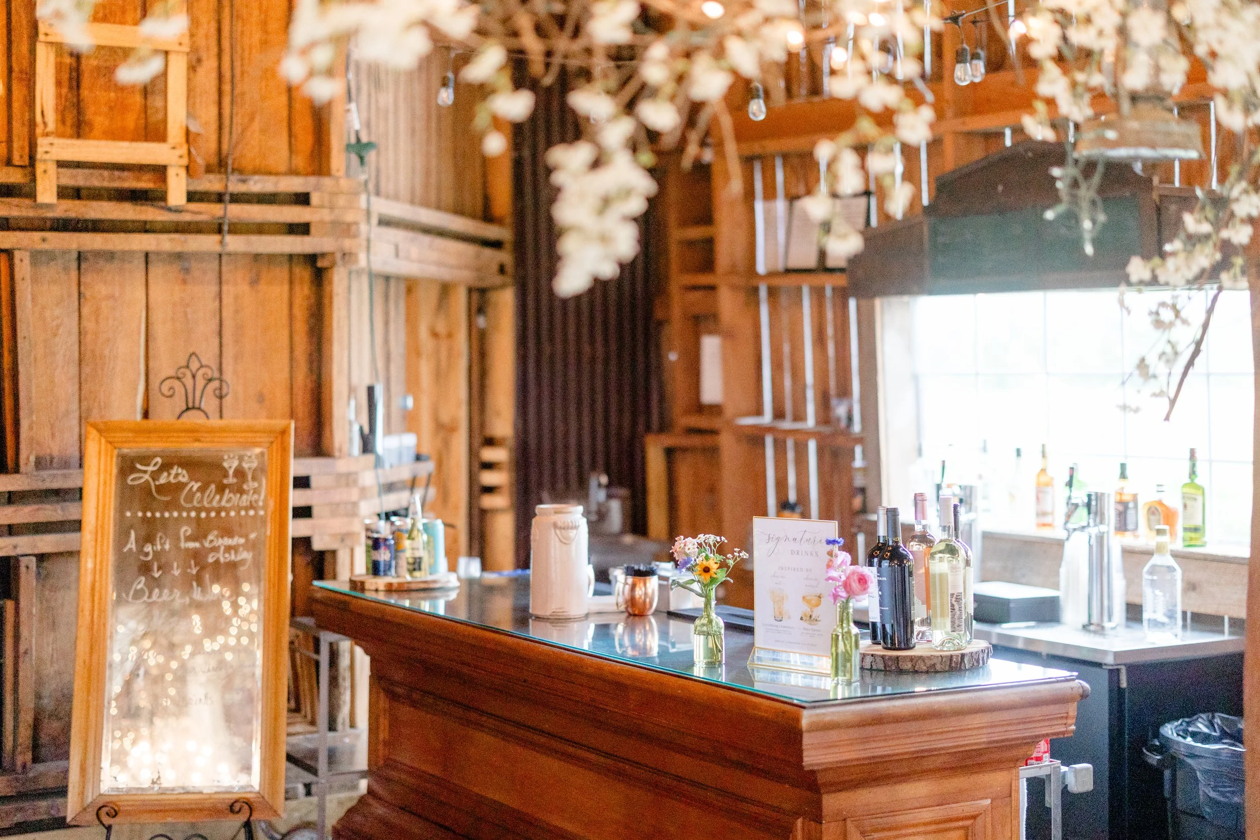 Rustic bar inside the Wedding Barn at Swiss & Bloom Farm with timber beams, vintage decor, and soft warm lighting.