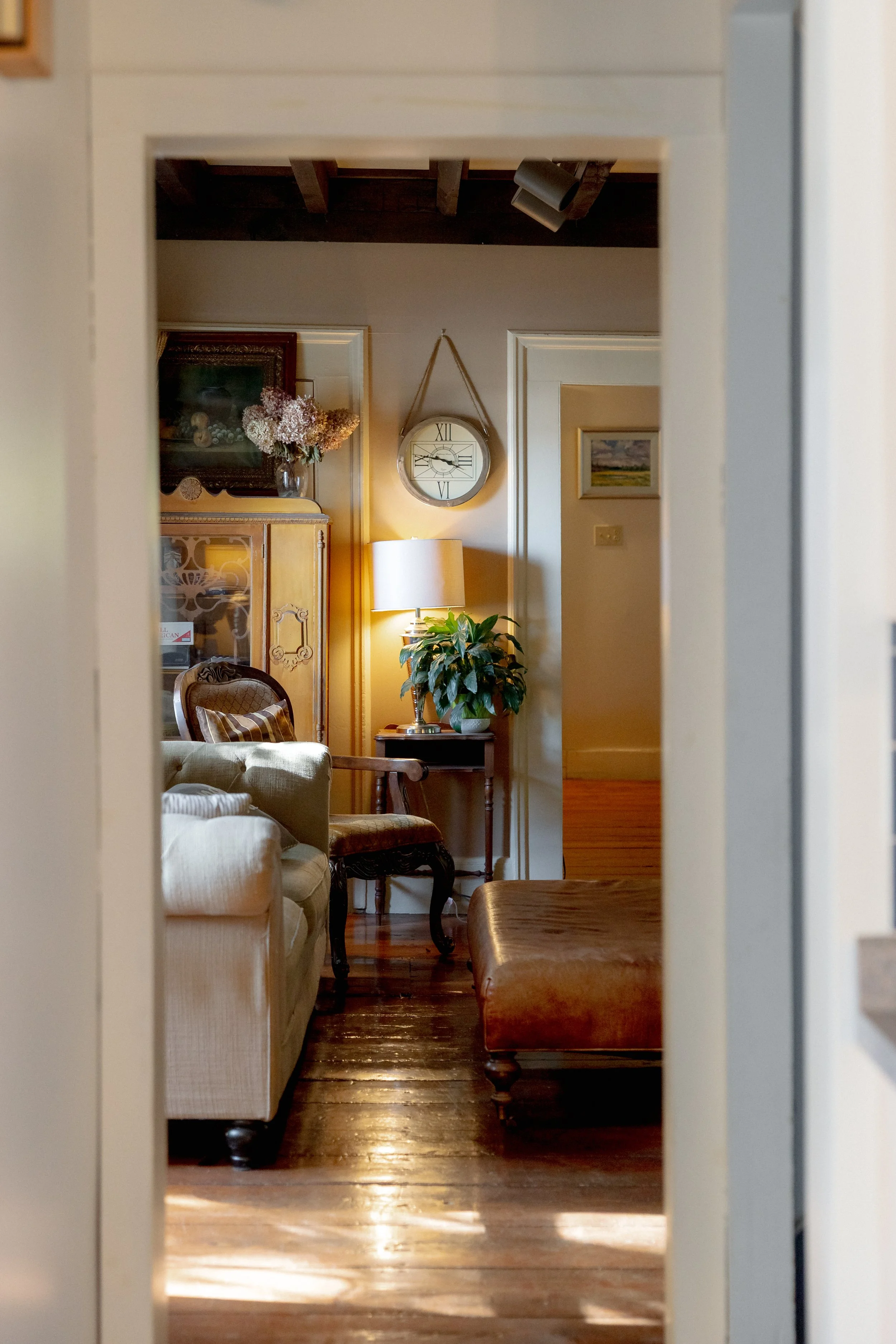Living room inside the Farmhouse at Swiss & Bloom Farm with wooden floors, comfortable seating, and natural light.