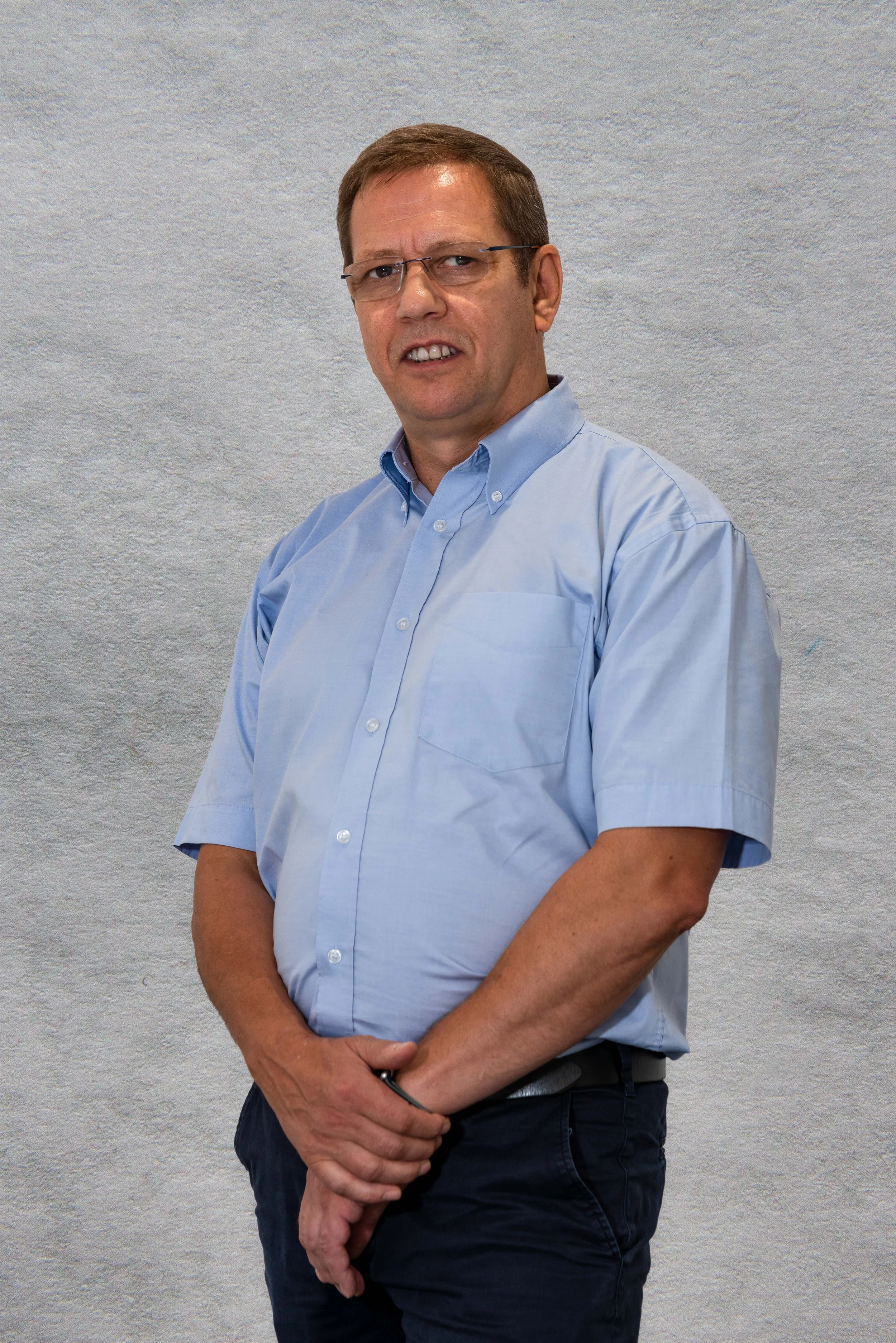 A photo of Keith in front of a grey wall