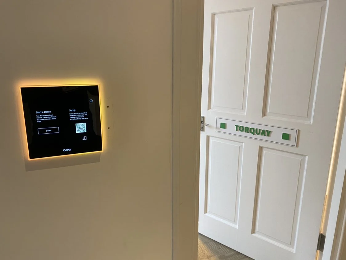 A digital touch screen panel on a beige wall with a glowing yellow border.