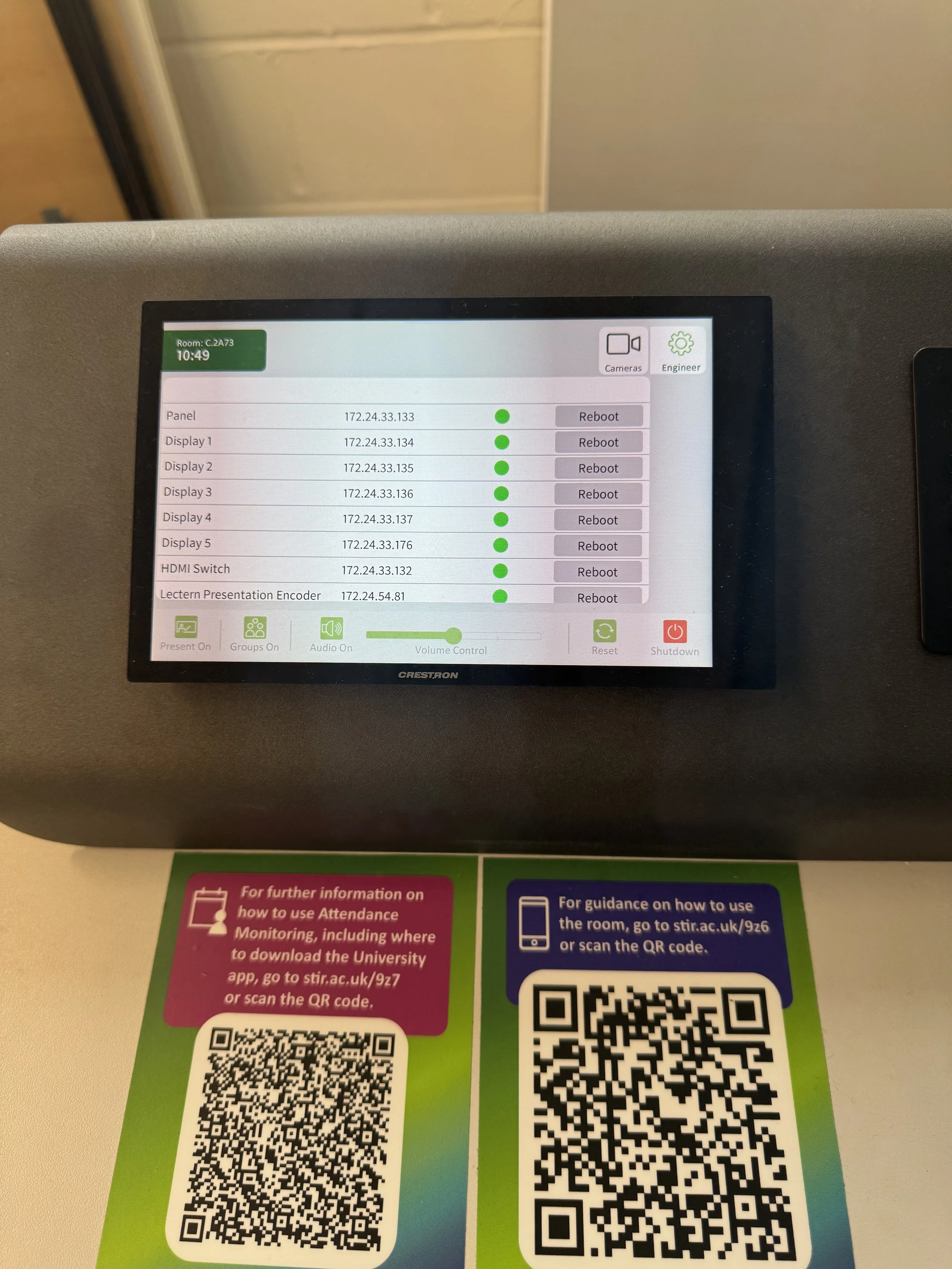 The image shows a screen on some electronic device displaying technical details and a list of IP addresses, each with a status indicator and reboot option. Below the screen, there are colorful informational pamphlets about how to use attendance monitoring and scanning QR codes.