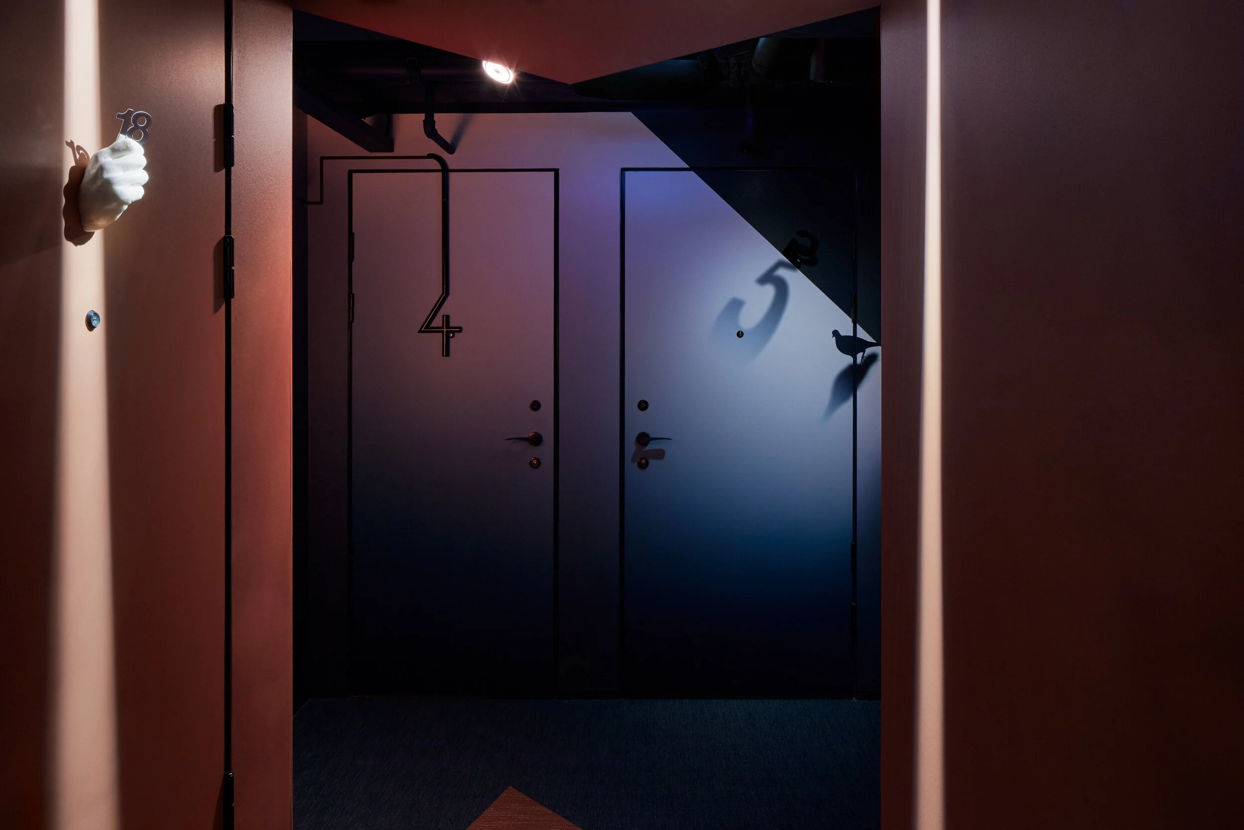 Zzz Dreamscape Hotel - Hotellrumsdörrar - vit skulpturhand på vänster vägg - rött och mörkt sken.jpeg