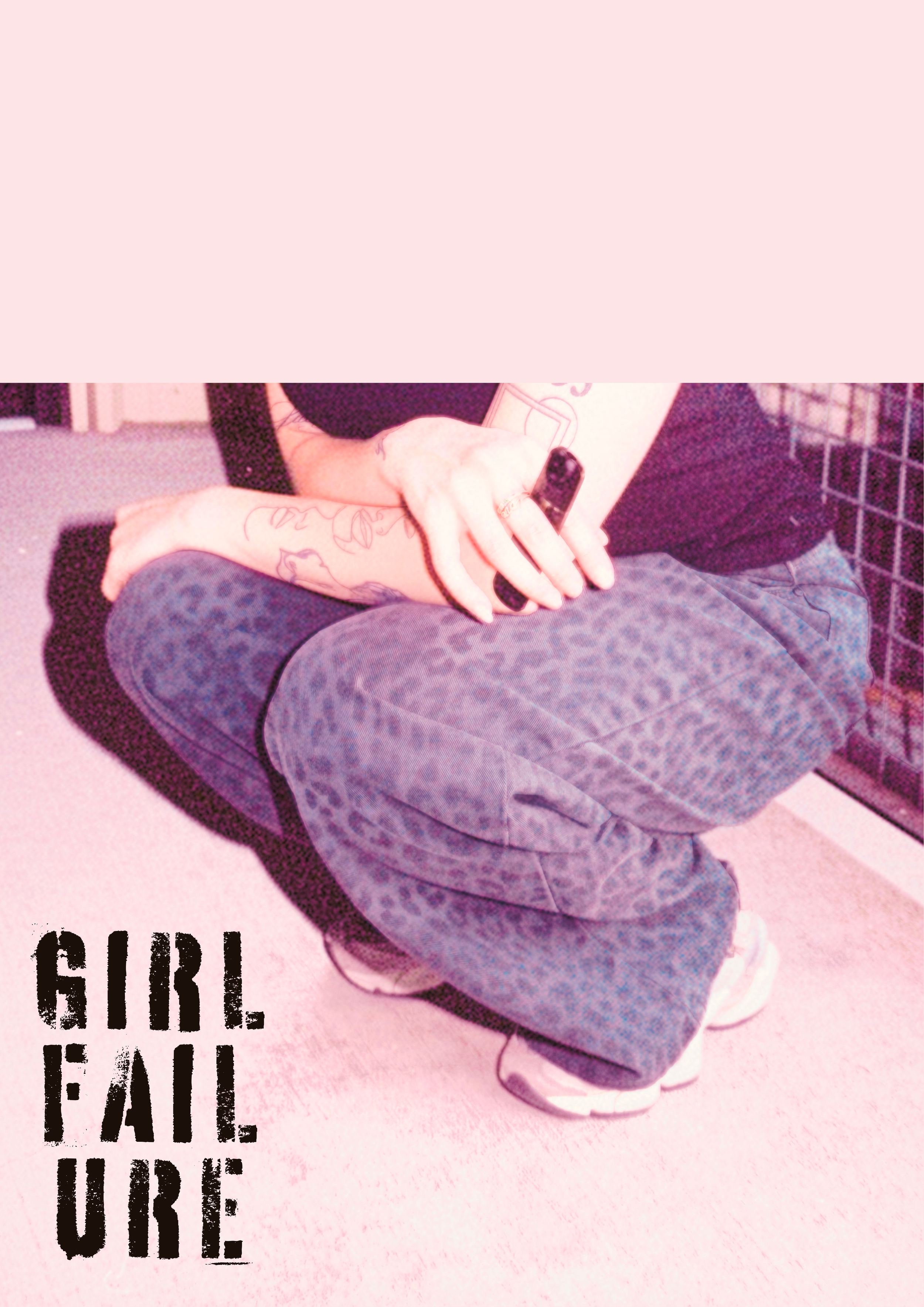 Person kneeling on the floor, holding a smartphone, wearing dark clothing and patterned pants, with tattoos on their arm. The background shows a pink surface and some wire shelving. Text in the lower left corner reads "GIRL FAILURE" in bold black letters.
