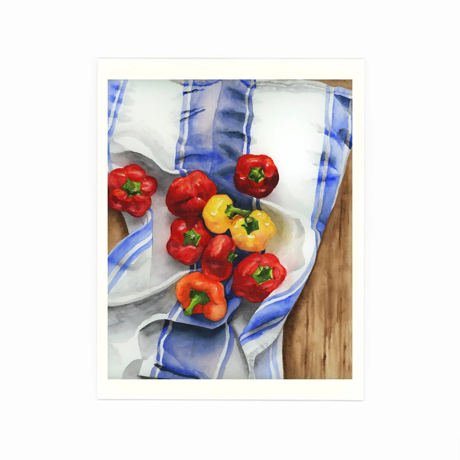 A watercolor painting of red and yellow bell peppers on a striped blue and white cloth on a wooden surface.