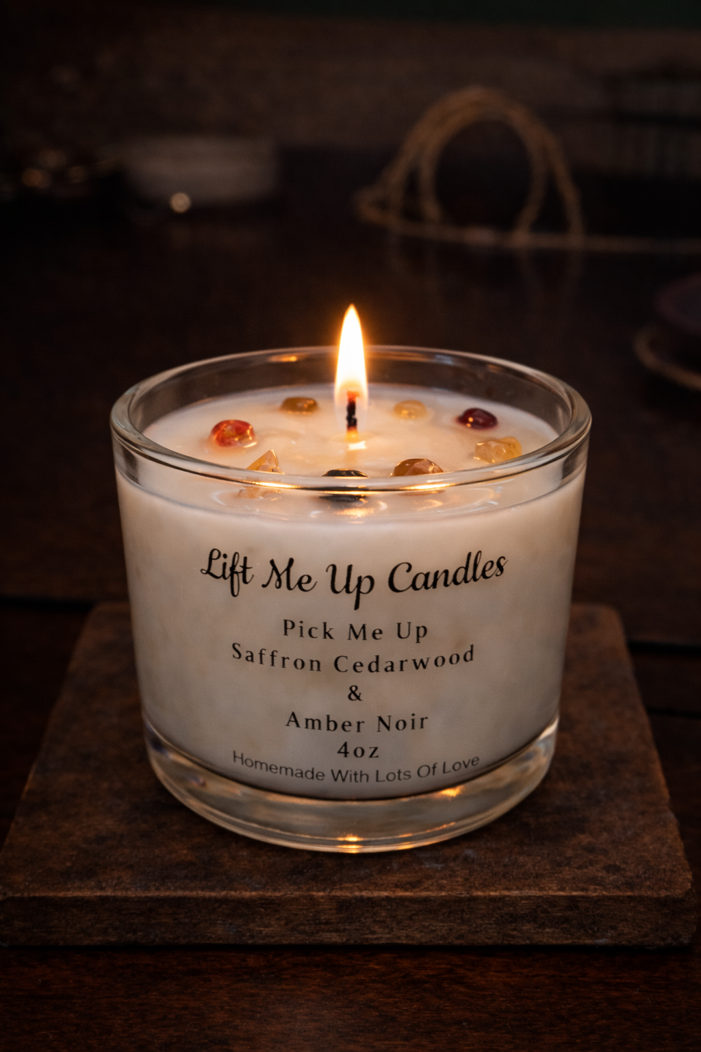 Handmade scented candle in glass jar with label and warm glow.