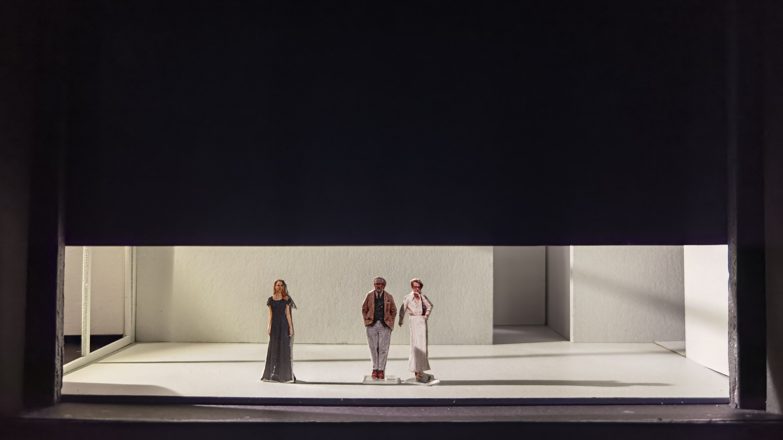 Three miniature figures on a miniature stage set