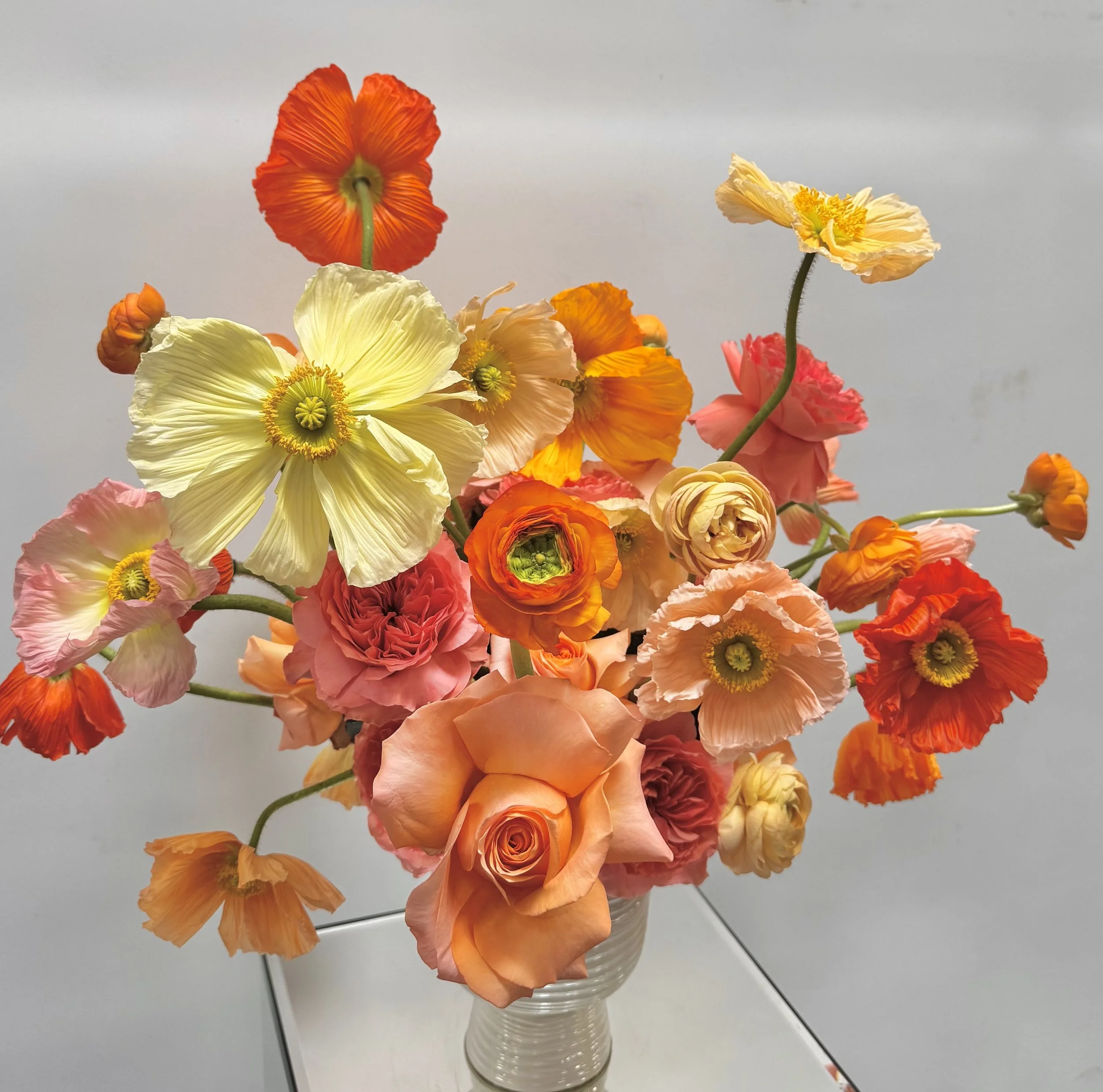 Ranunculus and poppies beautifully arranged for custom special event.