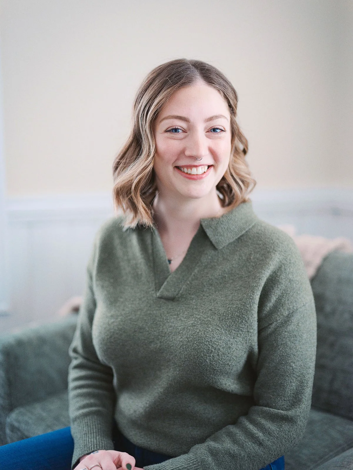 smiling woman with blonde hair and a green sweater