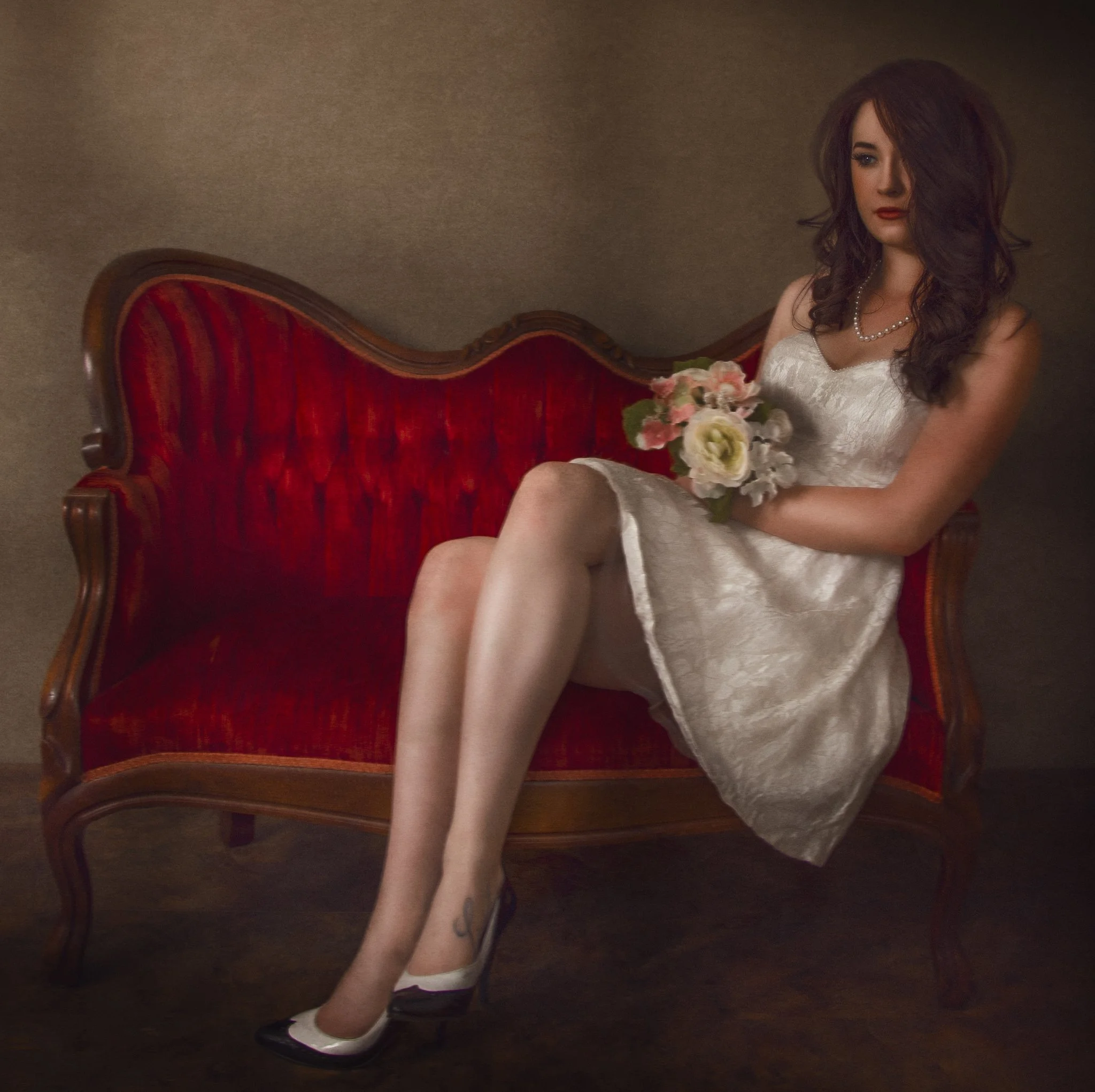 Classic fine art portrait seated on red vintage couch