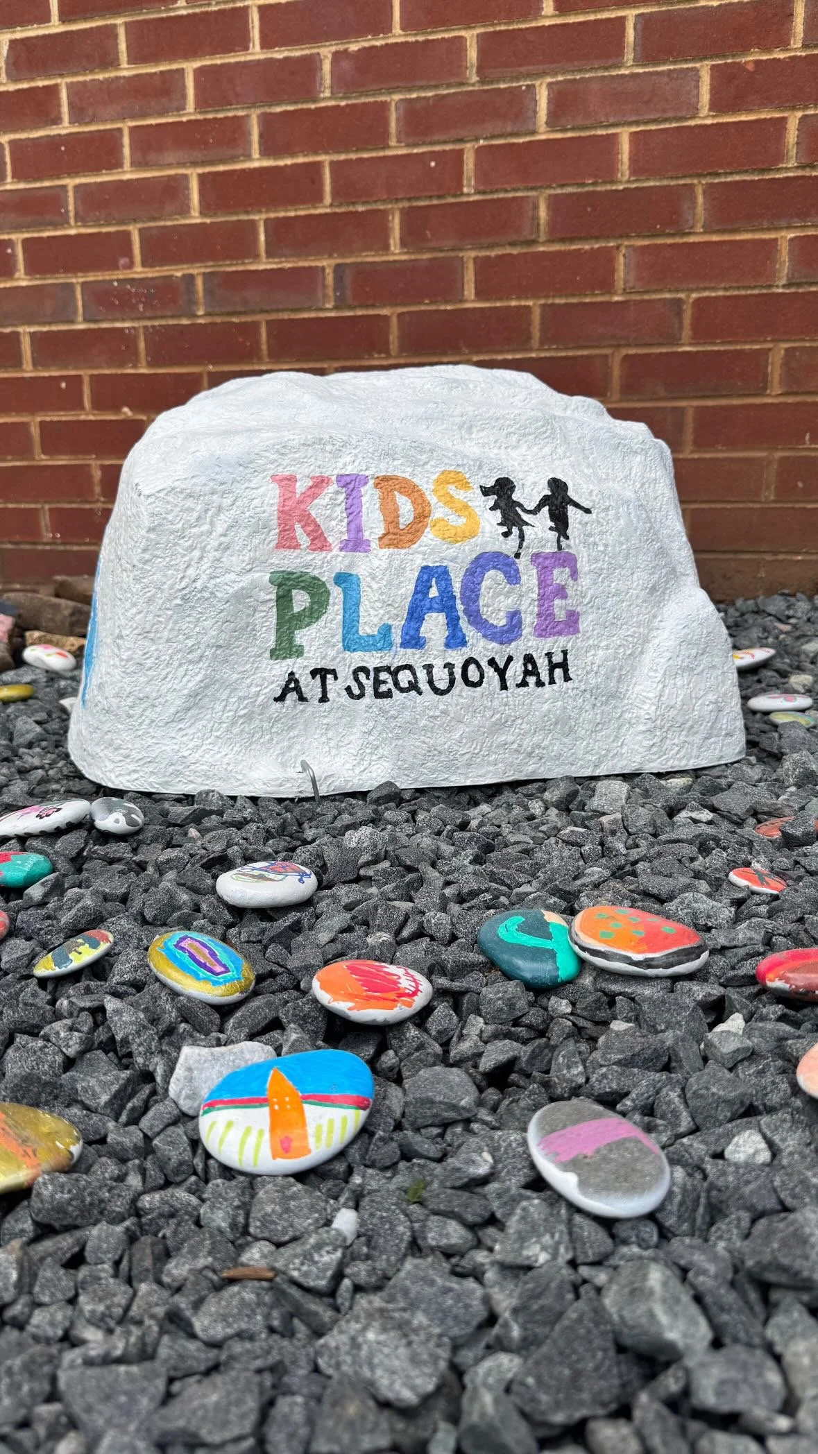 The logo on a rock right outside the entrance to kids place