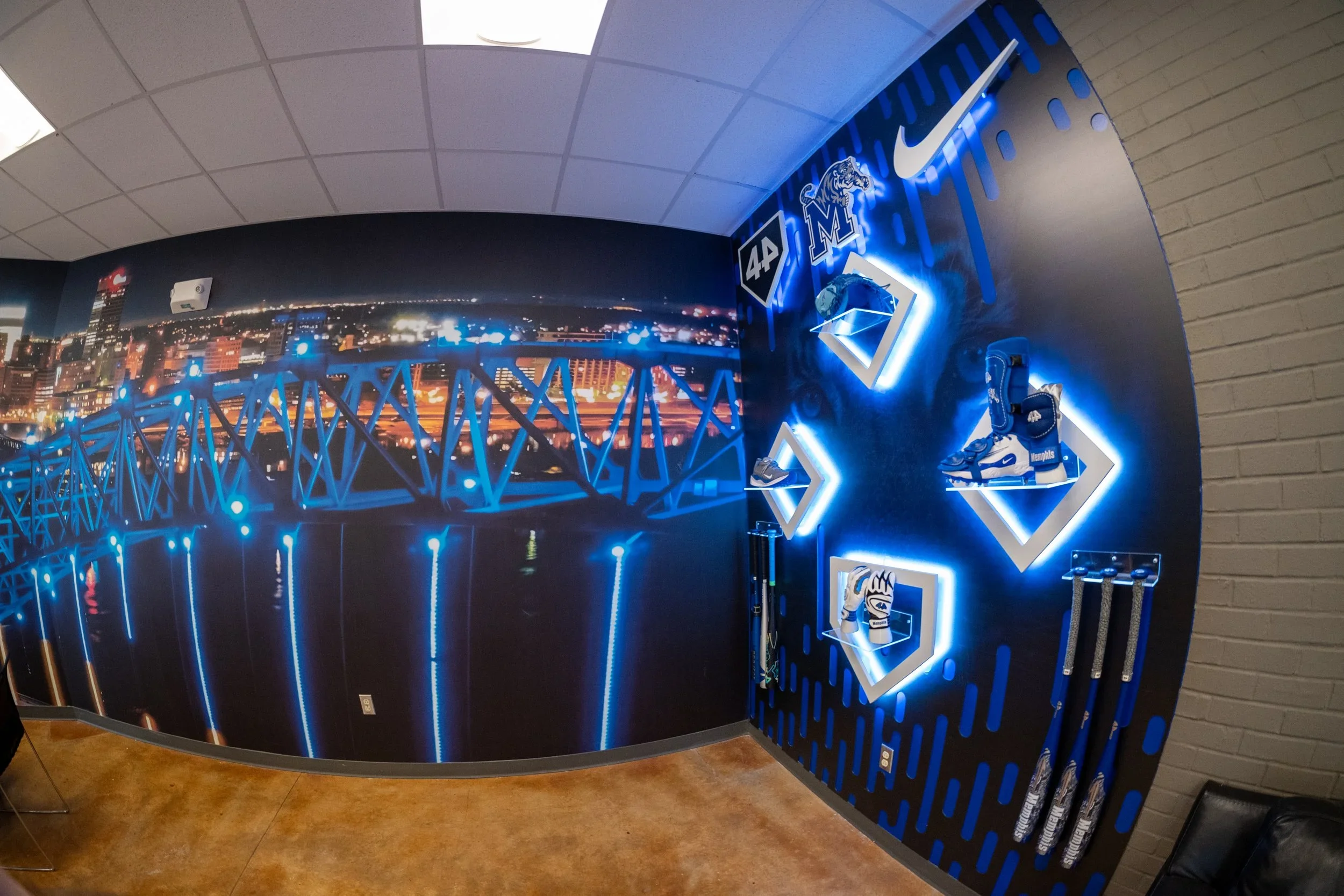 Display wall themed around Memphis sports, featuring logos, shoes, gloves, and other memorabilia, with a cityscape mural in the background.