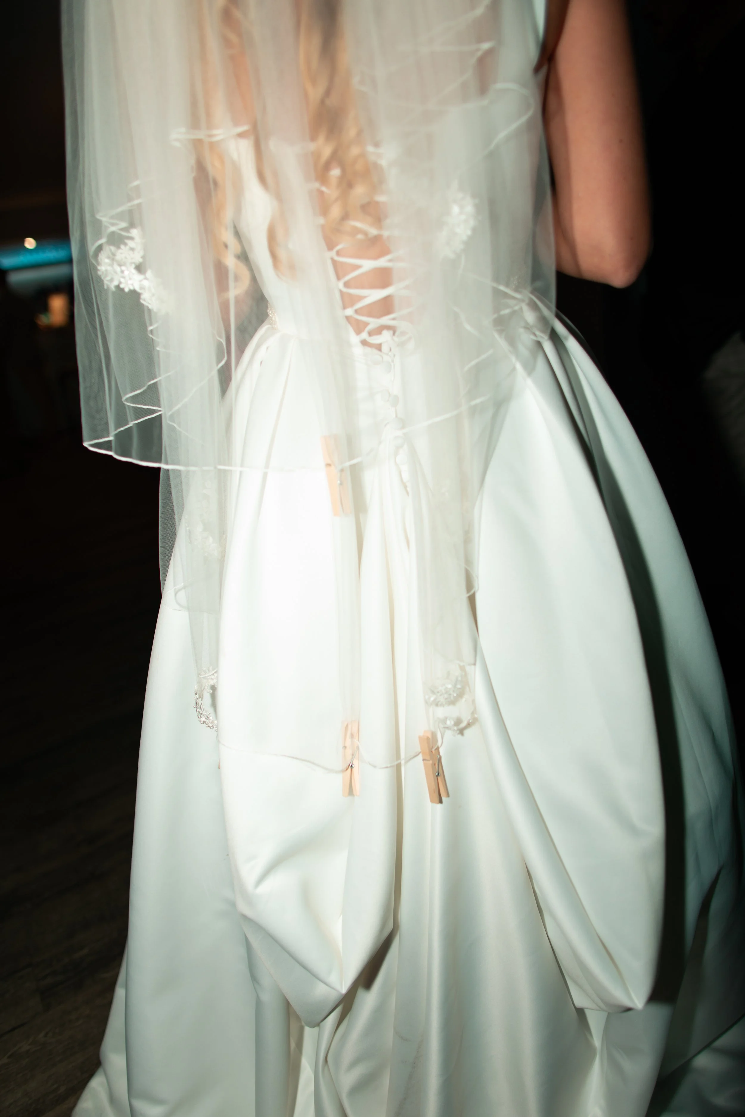 A wedding dress with a lace-up back and a tulle veil.