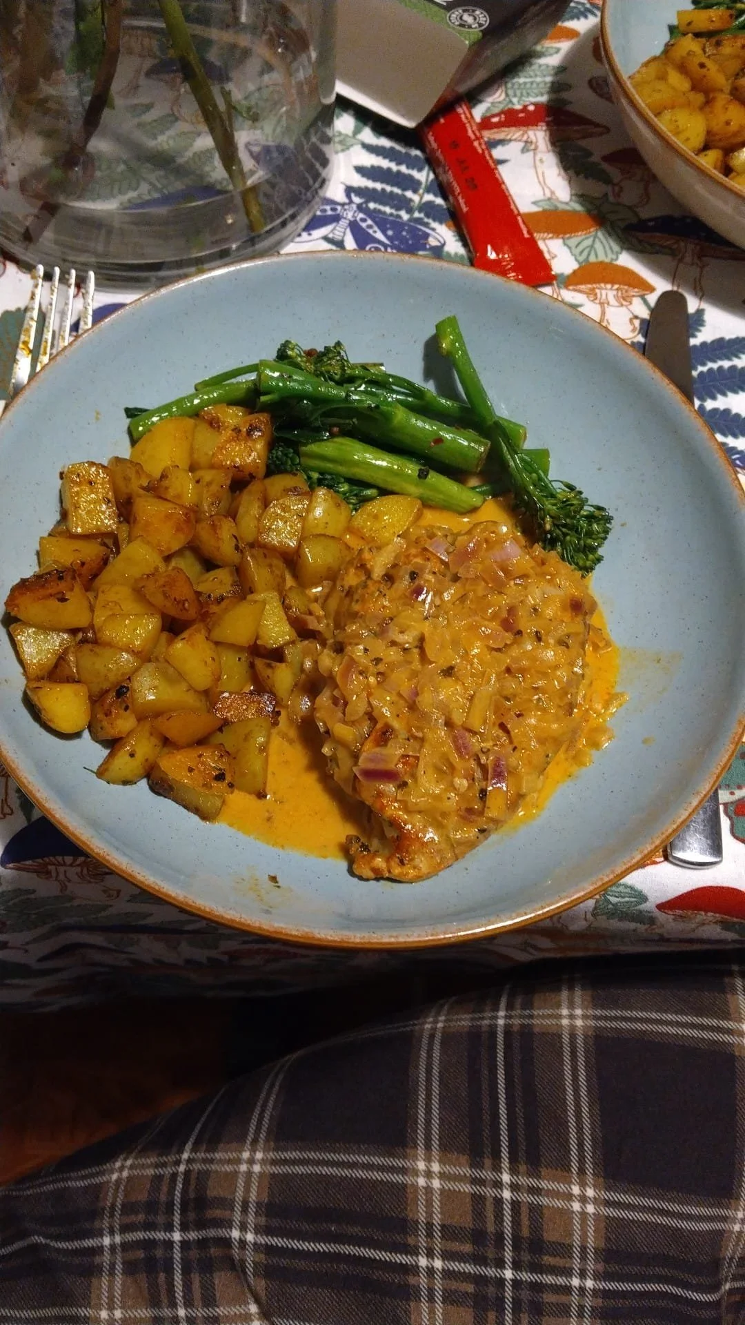 A plate of roasted potatoes, cooked green beans, and a baked fish fillet topped with a creamy sauce with diced vegetables.