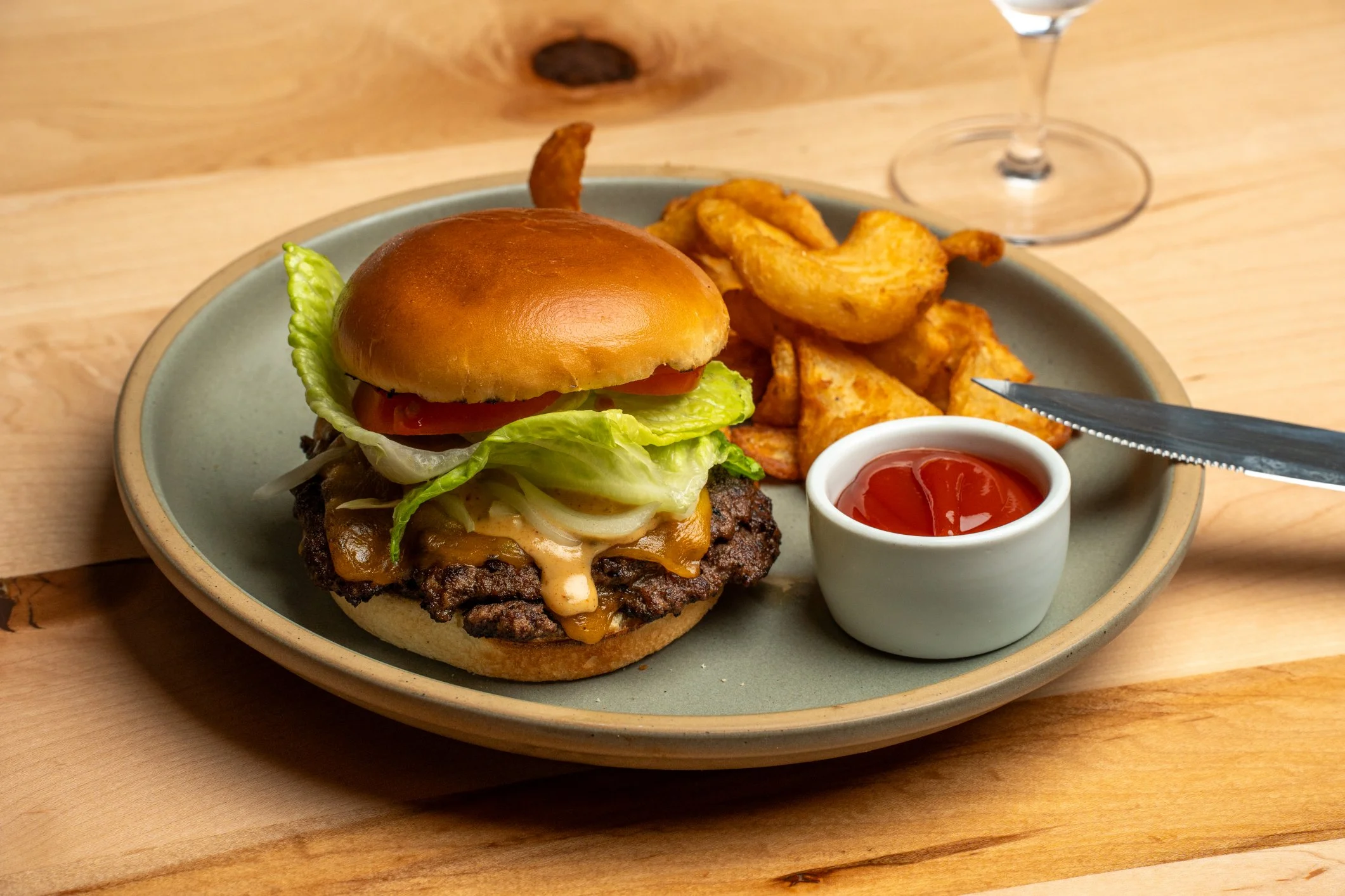 Plate with cheeseburger, potato wedges, and ketchup