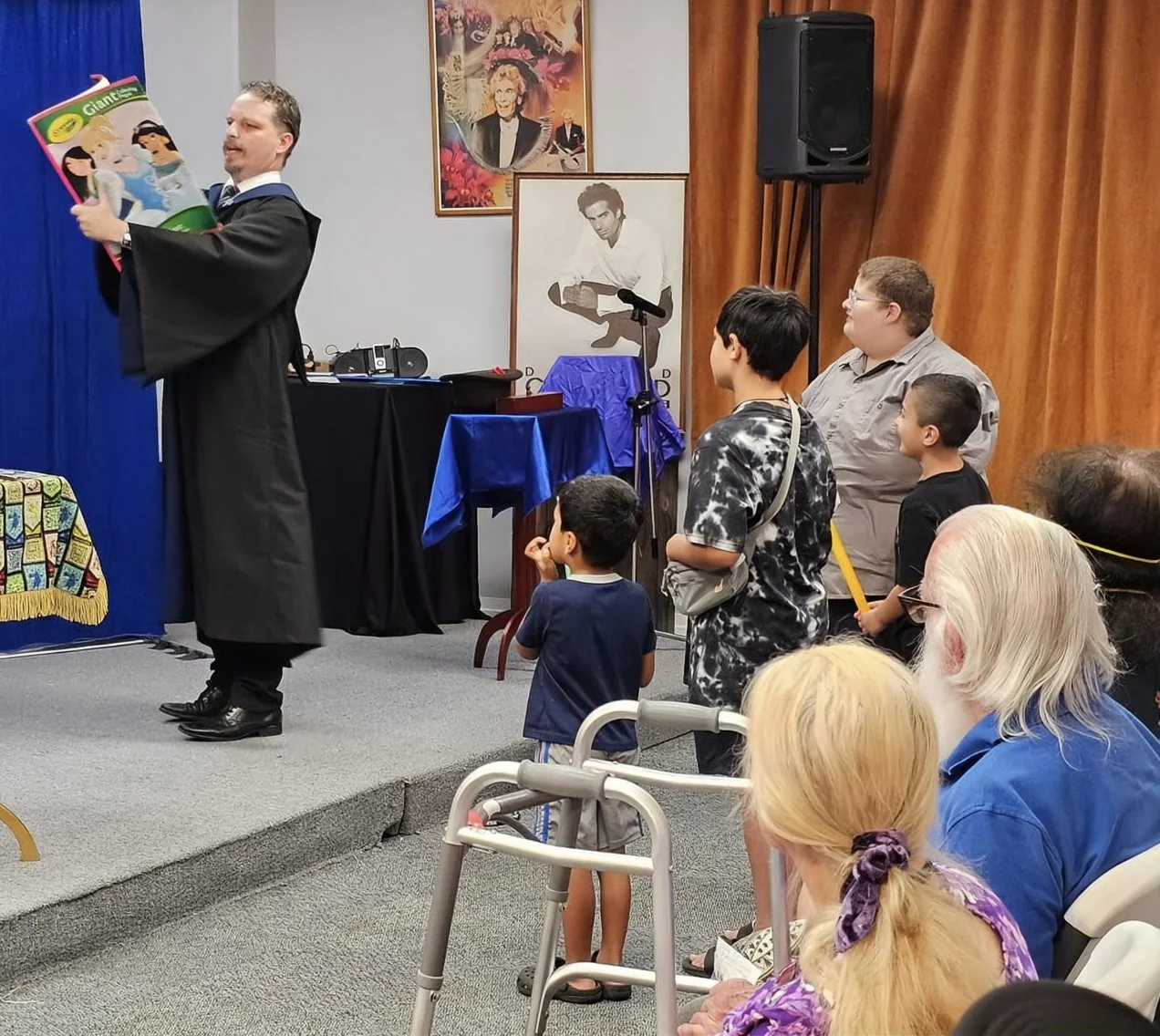 John performing at the Whittier Museum for the SAM Hall Of Fame. He presents a coloring book trick for four children with wands. 