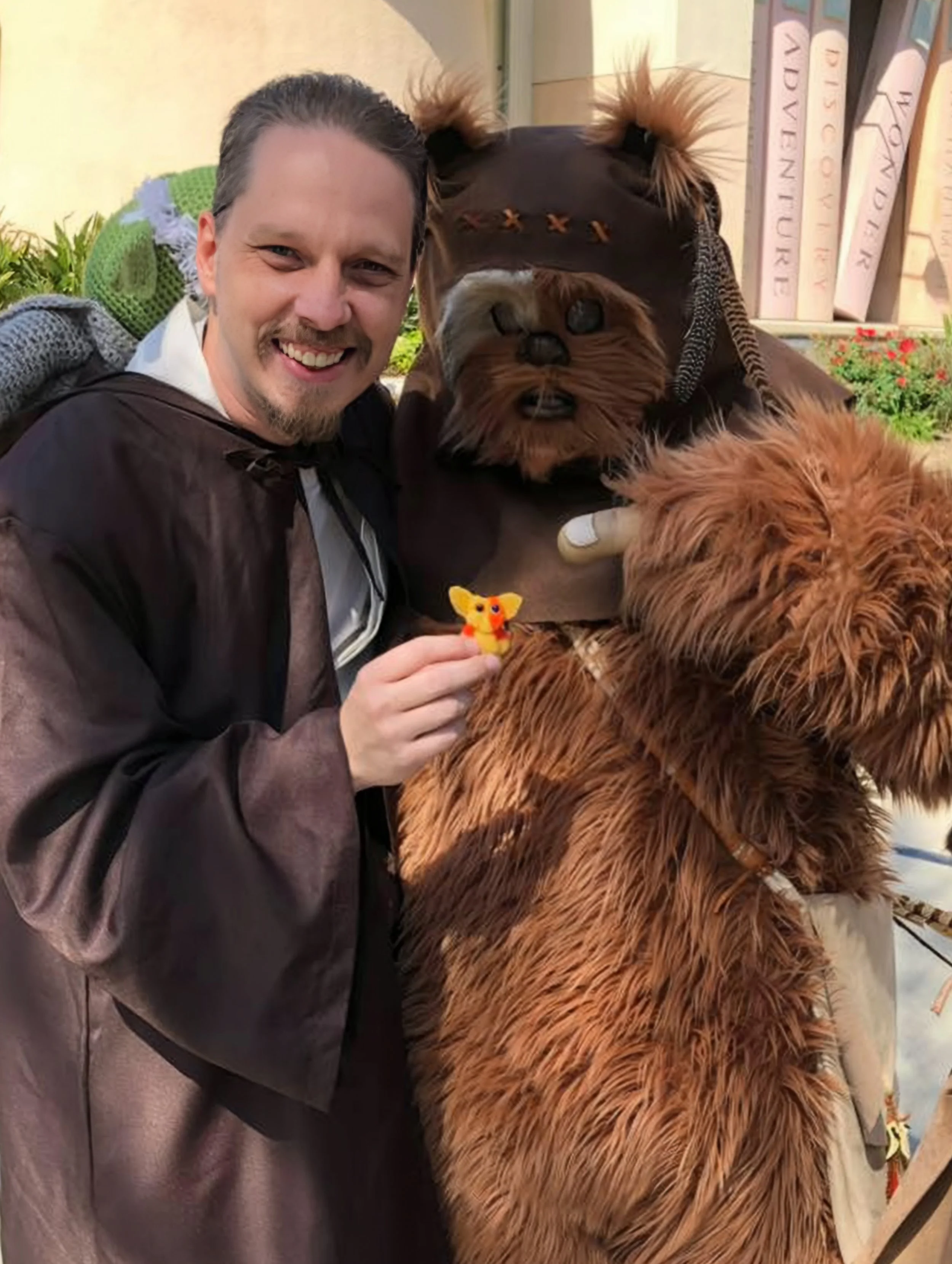 John holds a sponge ewok with an ewok in costume pointing at it