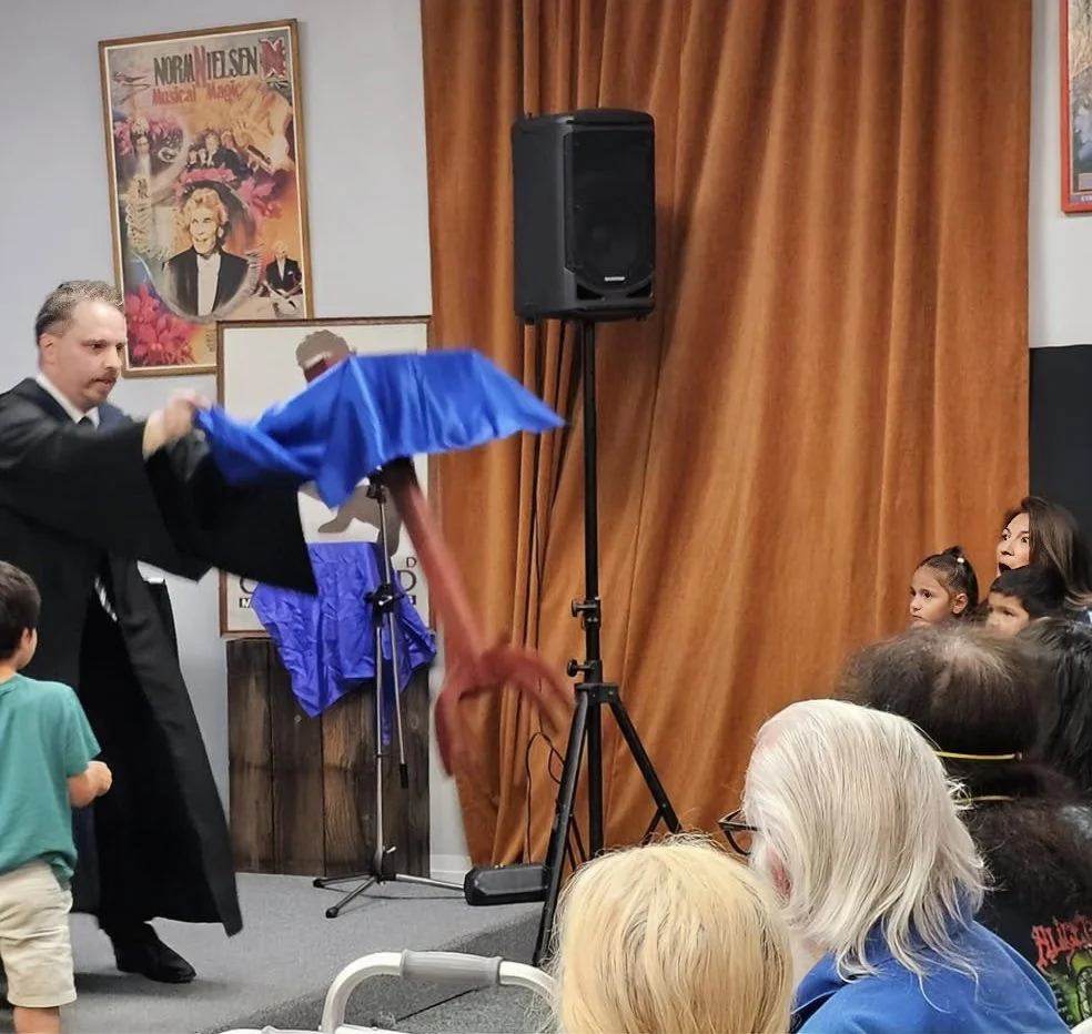 John performing at the Whittier Museum for the SAM Hall Of Fame. A table floats while a child points their wand