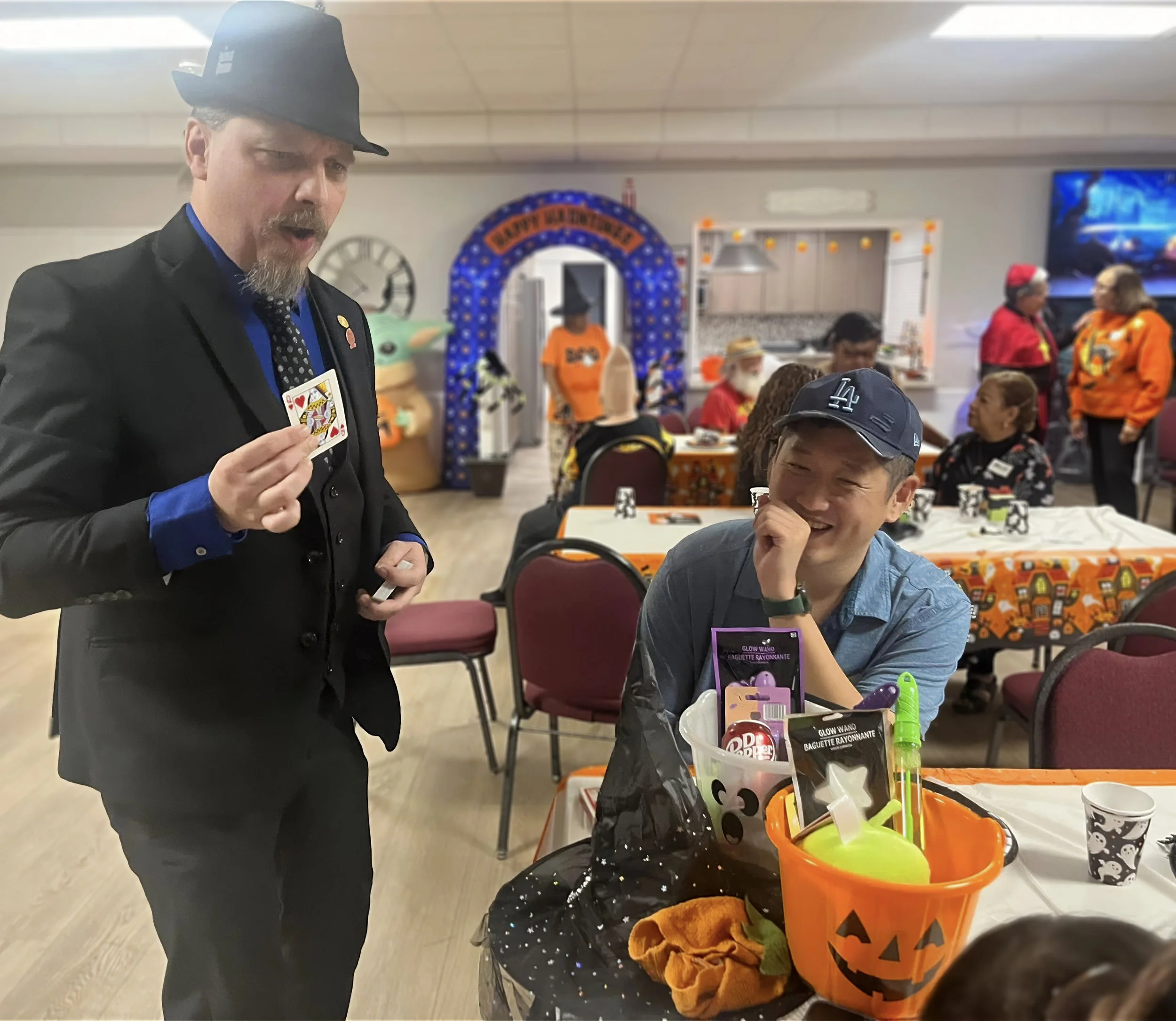 John performs a card trick at a Halloween gathering
