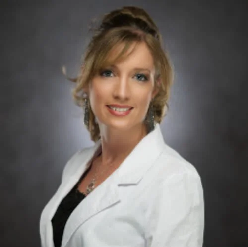 Veterinarian holding two small dogs, a white Chihuahua and a black and white Chihuahua, in a veterinary clinic.