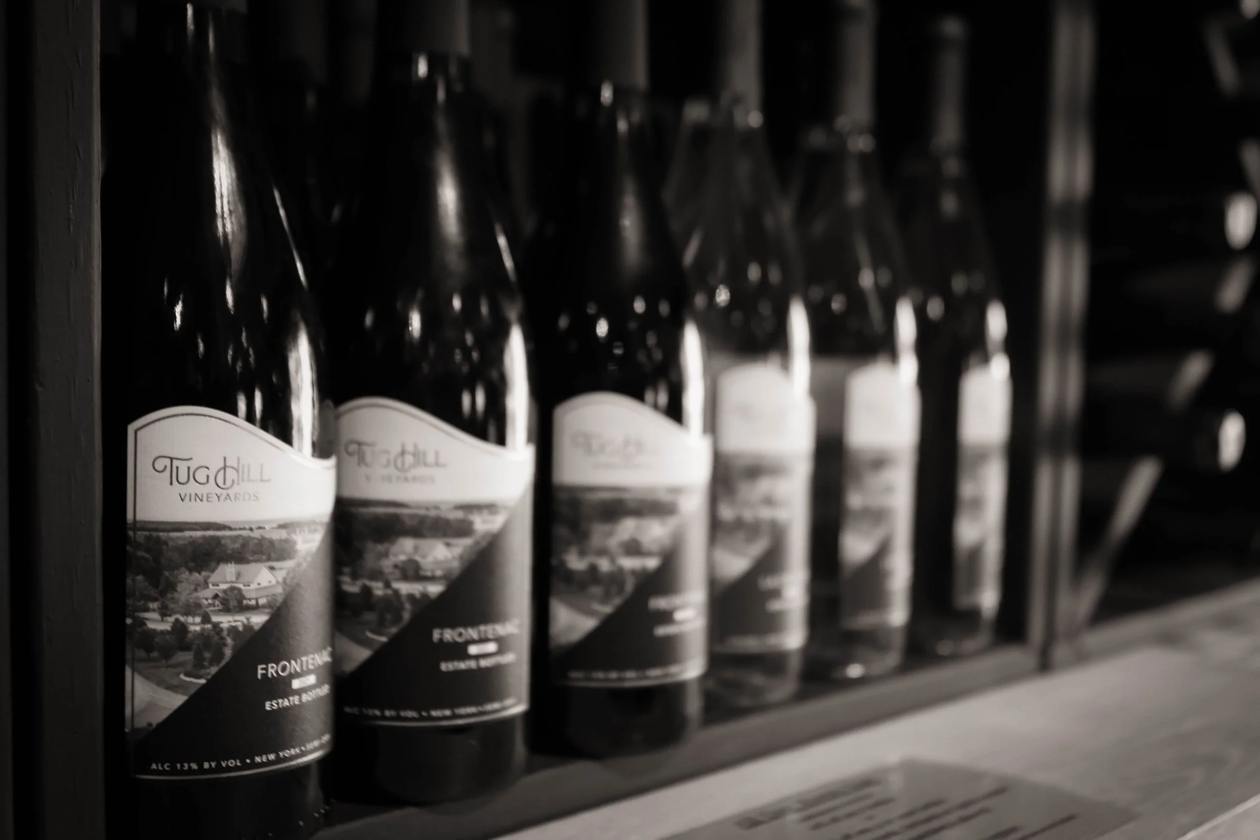 Rows of wine bottles on a shelf in a store.