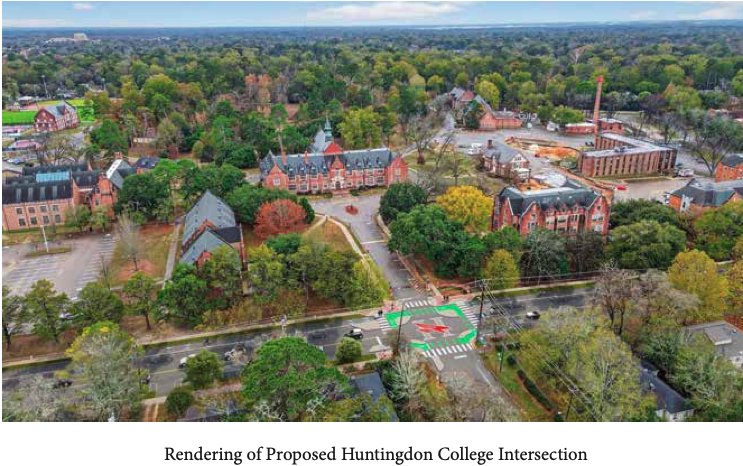 Aerial view of a college campus with historic buildings, trees, parking lots, and a newly painted intersection with green and red markings indicating a bicycle and pedestrian crossing.
