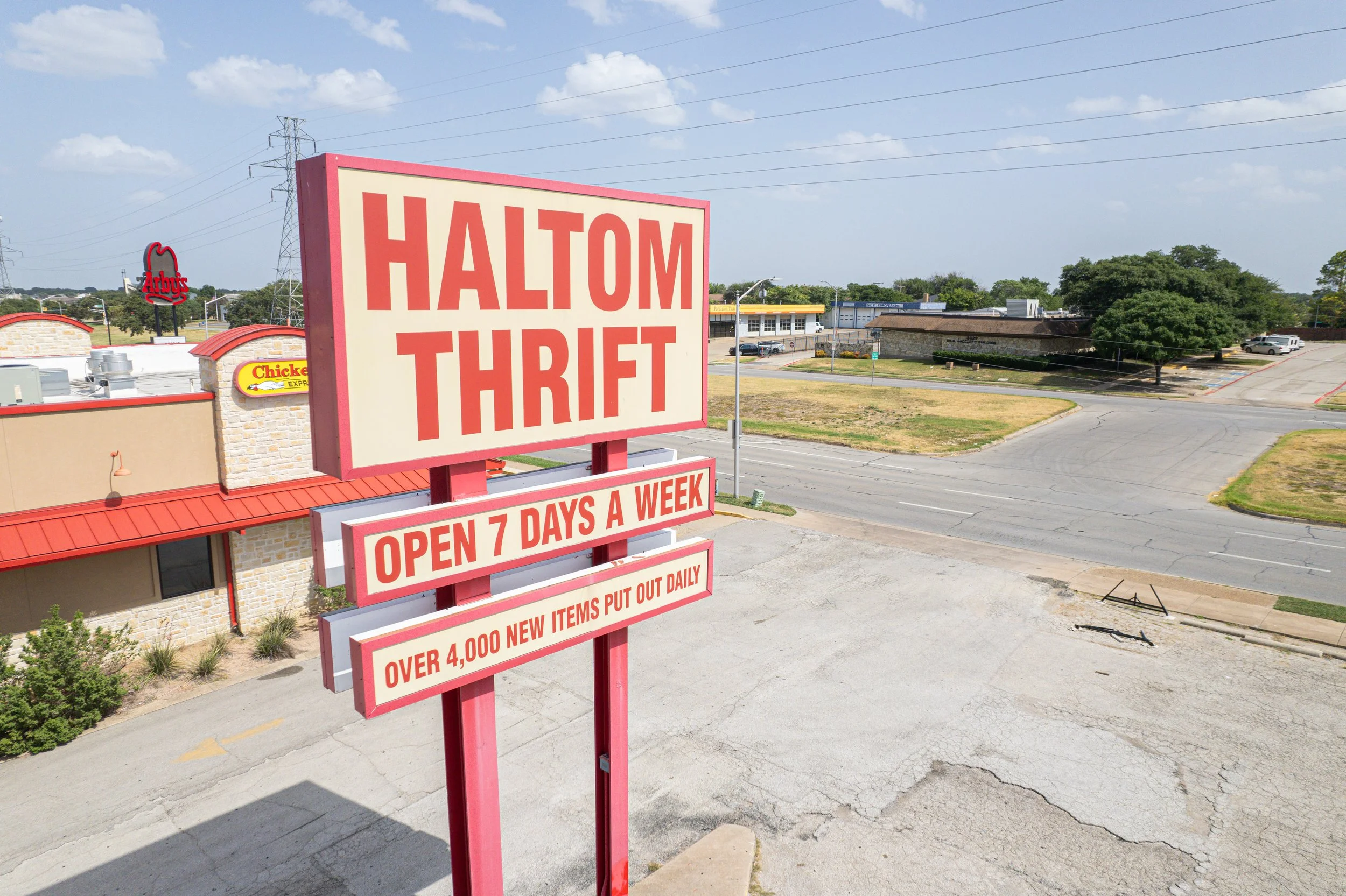 Haltom Thrift store sign advertising open 7 days a week with over 4,000 new items daily, located in Forth Worth, DFW