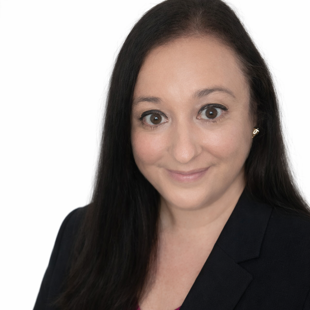 portrait of a woman with long dark hair, looking at the camera with a slight smile.