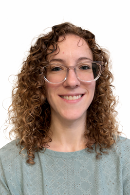 A woman with curly hair and glasses smiling, wearing a light-colored top against a white background.