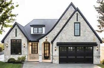 Modern house with stone exterior, front door, large windows, and an attached two-car garage