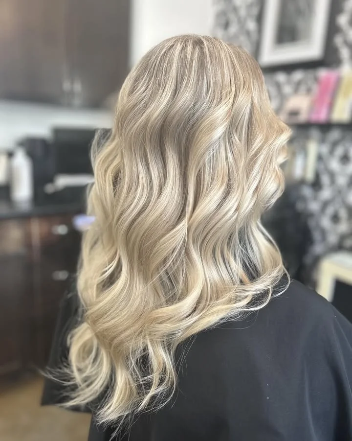 Blonde wavy hair on a person sitting in a salon.