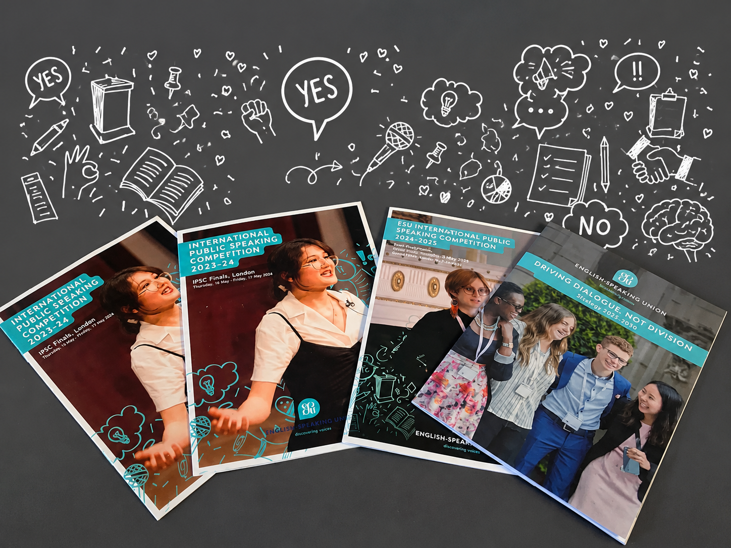 Brochures of ESU International Public Speaking Competitions 2023–2025 and ESU Strategy 2025–2030 displayed on table.