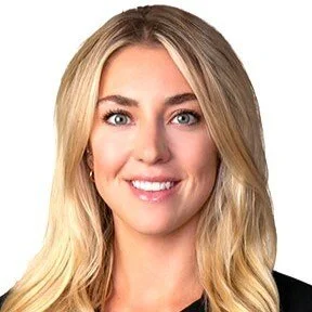 Professional headshot of a smiling blonde woman with blue eyes and natural makeup