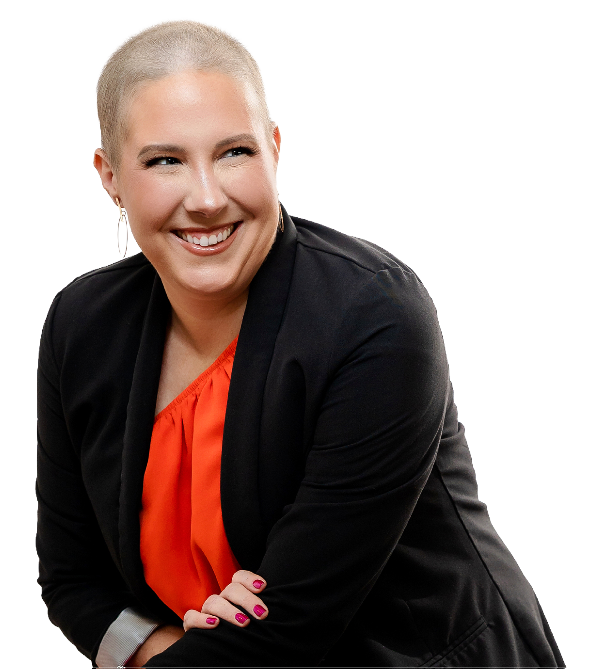 A woman with a platinum blonde buzz cut smiling, wearing a black blazer over an orange top, with pink nail polish, and large earrings.