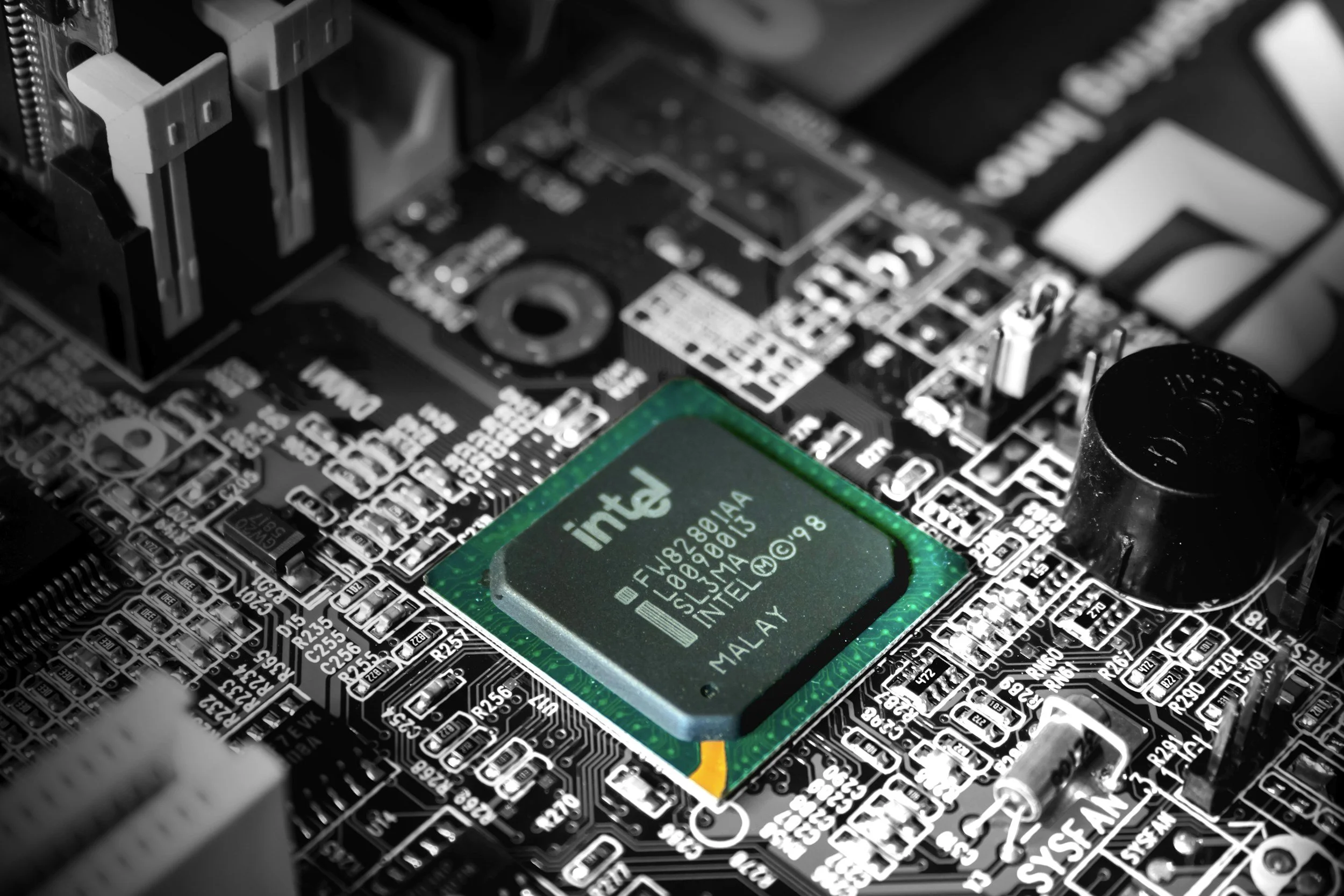 A close-up image of a computer motherboard with an Intel processor installed in the center.