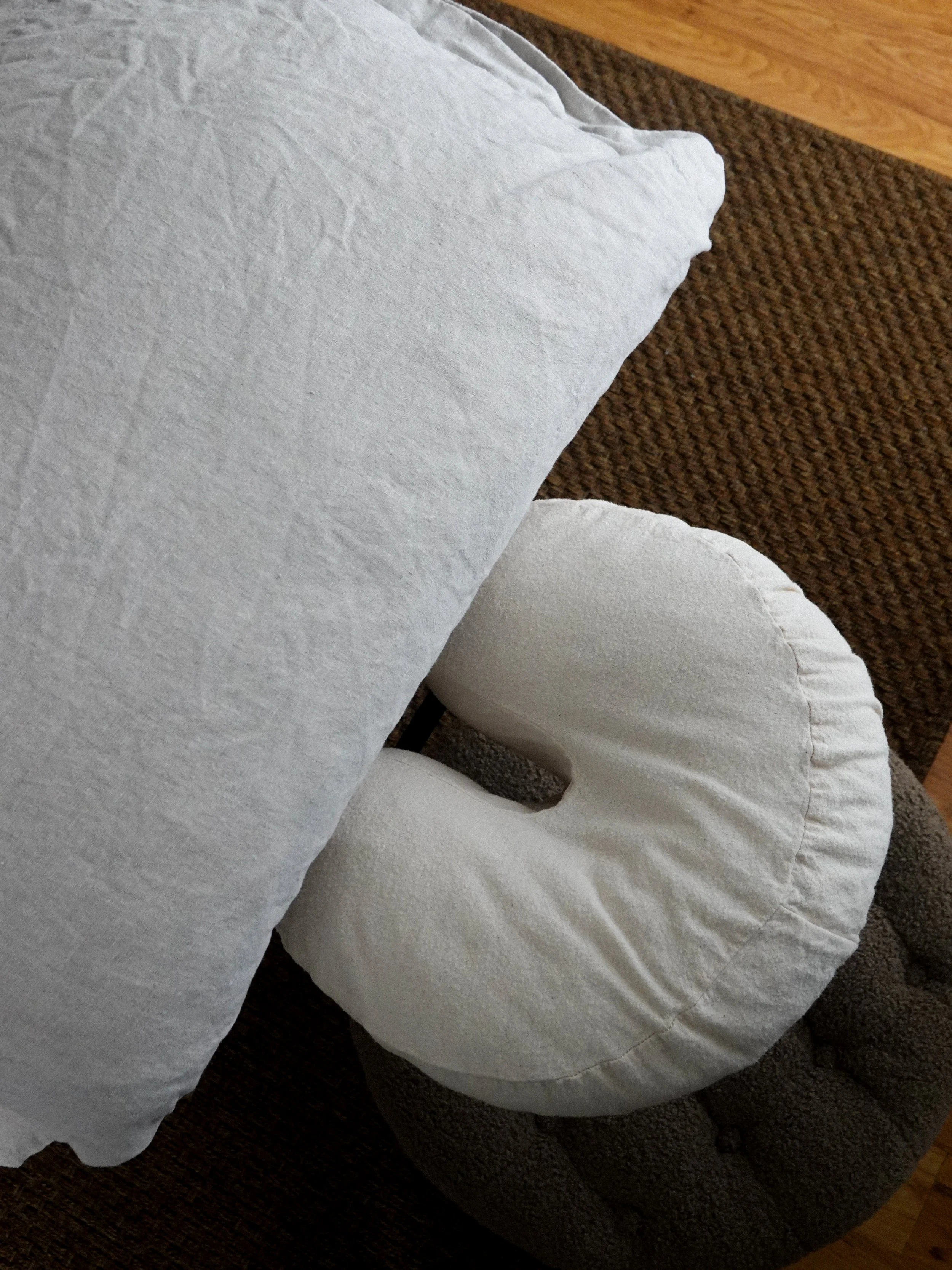 Close-up of white foam cushioning materials placed on a brown upholstered chair with wooden armrest.